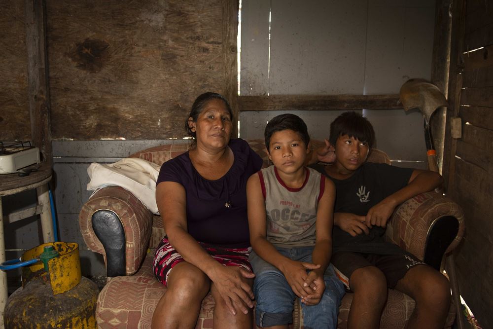 Eine Mutter mit zwei Söhnen in einer Hütte aus Brettern (Quelle: Christian Nusch)