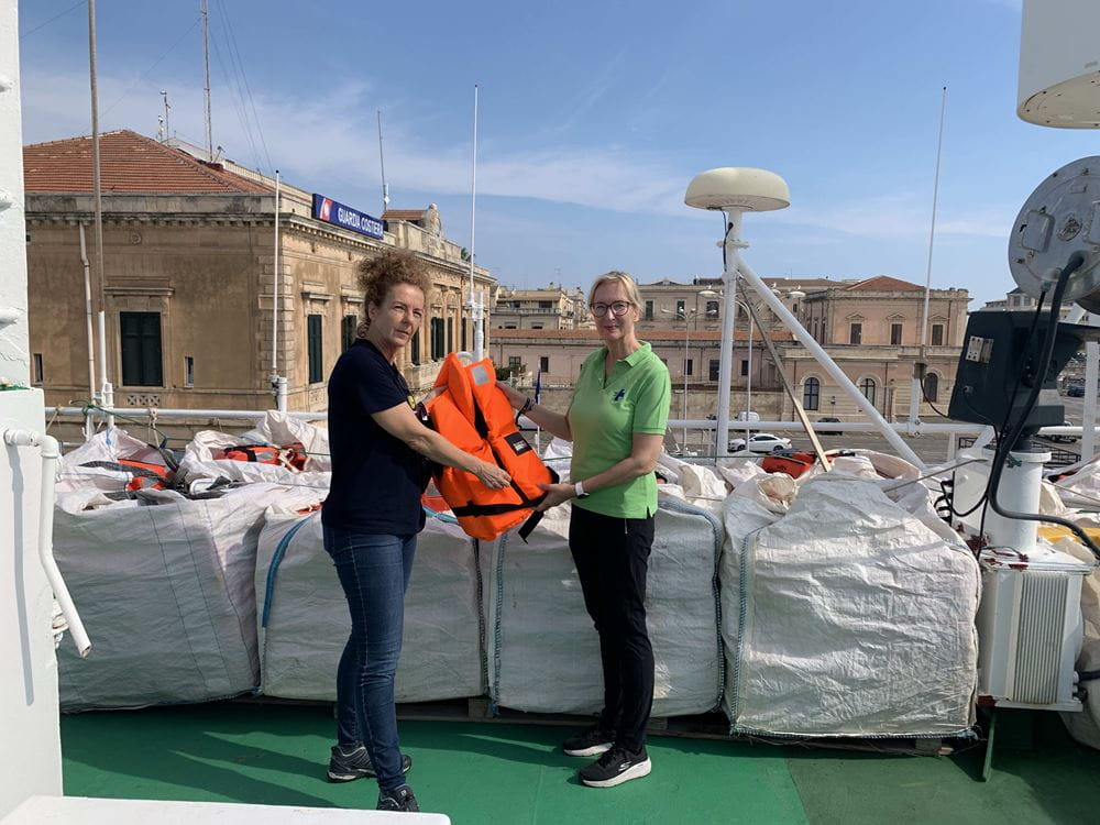 Zwei Frauen, die eine Rettungsweste halten, an Bord eines Schiffes 1 (SOS Humanity)