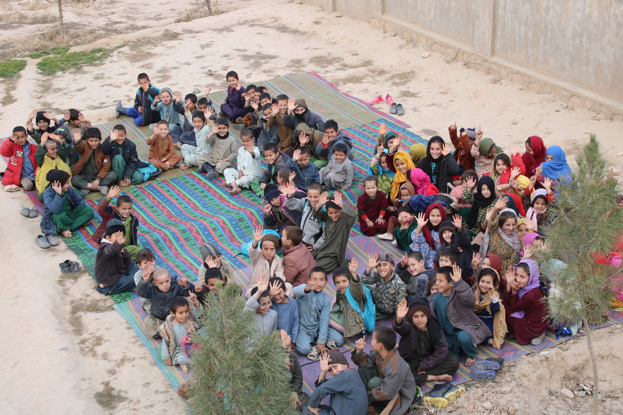 Kinder aus Afghanistan winken in die Kamera