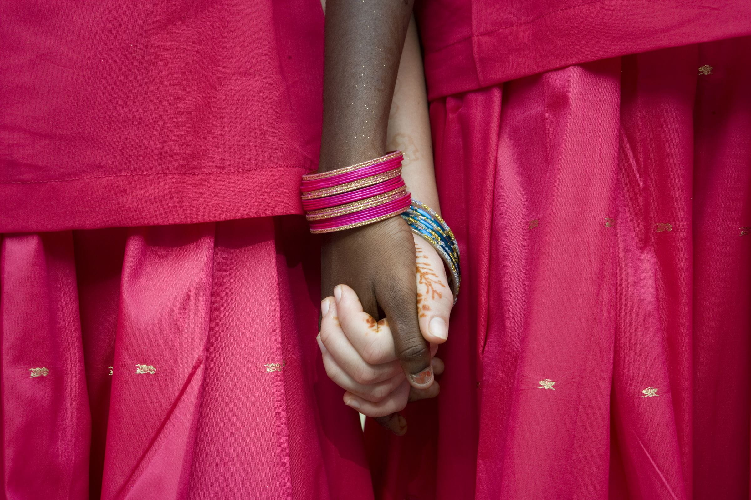 Zwei indische Mädchen in traditionellen Kleidern halten sich an den Haenden (Quelle: Frank Rothe)