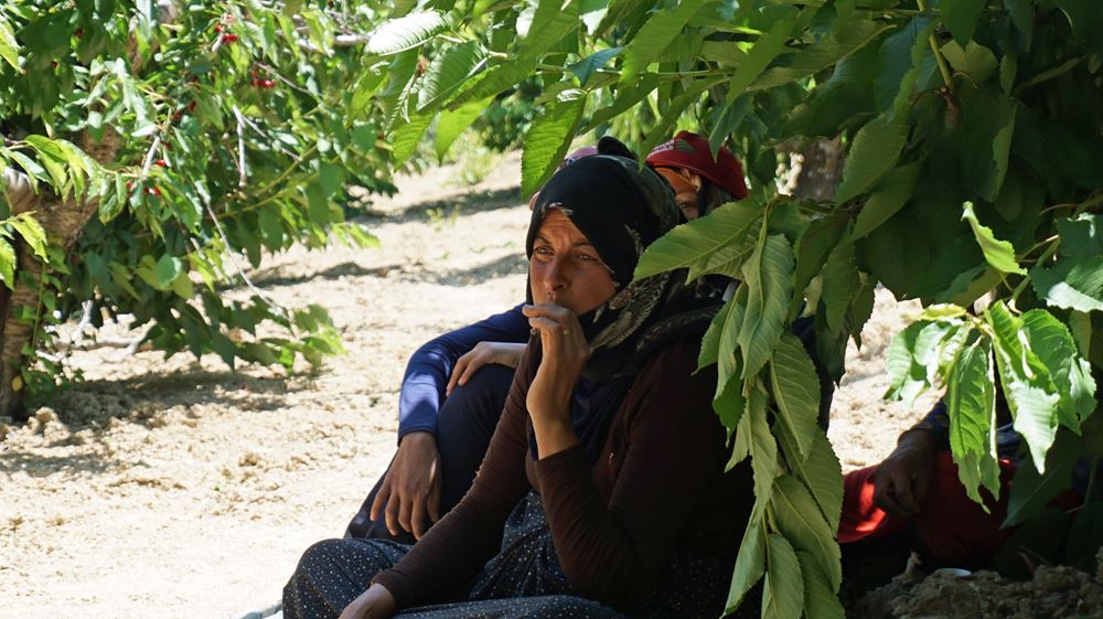 Reportage Libanon "Das Wichtigste ist eine Schule im Camp"; Foto: Frau unter einem Baum im Schatten sitzend (Quelle: Lorenz Toepperwien / Kindernothilfe)