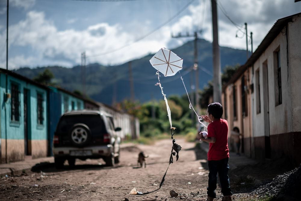 Ein Kind in einem Dorf in Guatemala mit einem Drachen