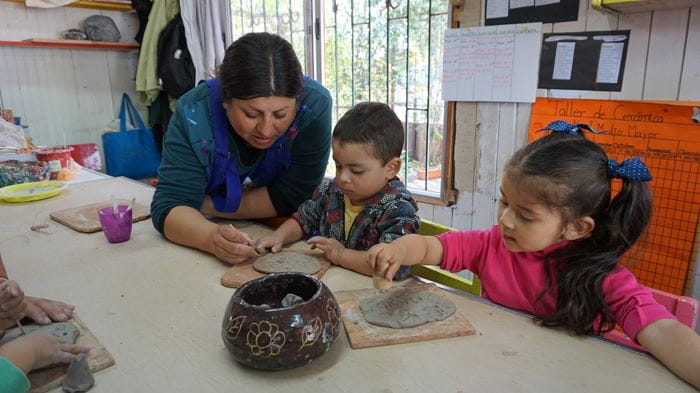 Kinder töpfern gemeinsam mit einer Betreuerin in einem unserer Projekte in Chile. (Quelle: Kindernothilfe)
