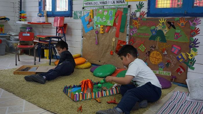 Zwei Jungen spielen auf dem Boden einer Kindergruppe in Chile. (Quelle: Kindernothilfe)