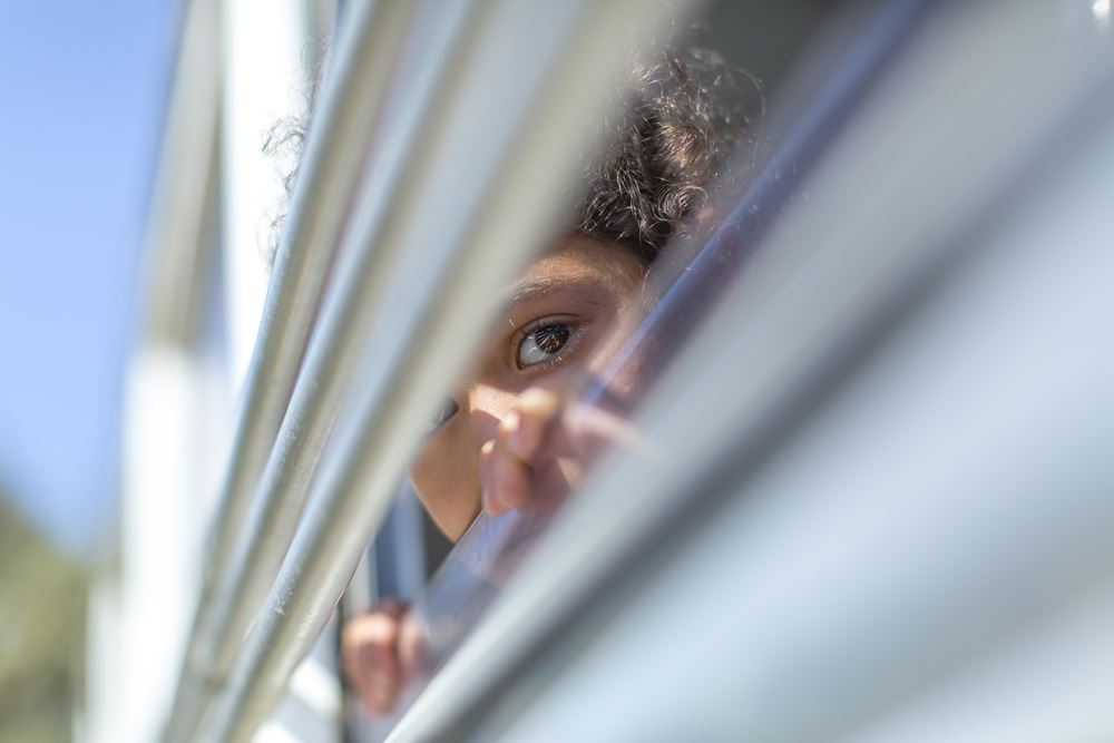 Ein Kind schaut aus einem Fenster (Quelle: Jakob Studnar)
