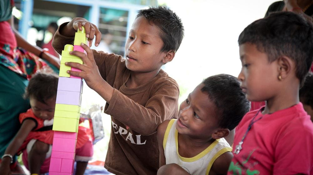 Nepal: Erdbeben 2015 Pressereise - Mit Bausteinen spielende Kinder