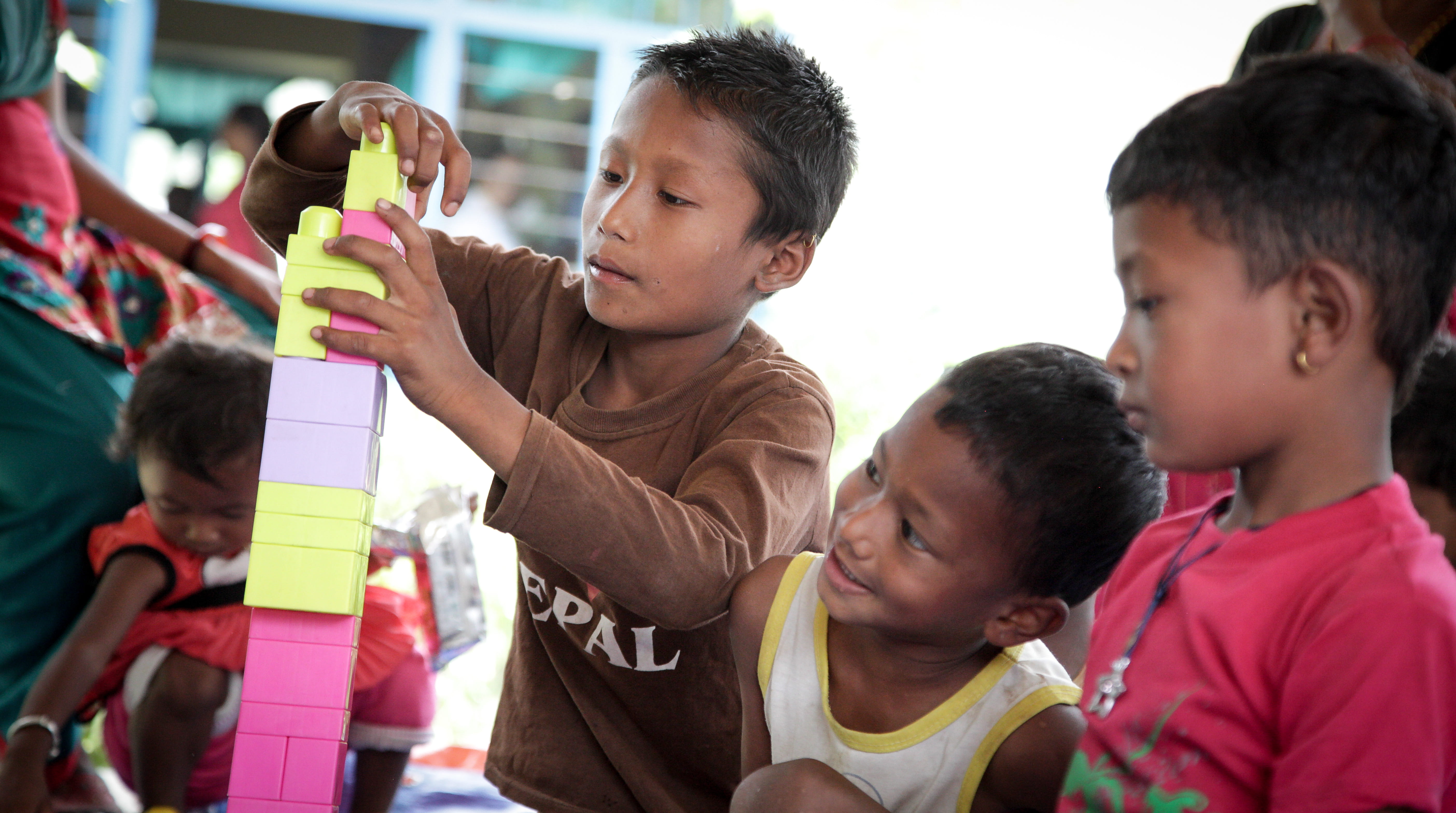 Nepal: Erdbeben 2015 Pressereise - Mit Bausteinen spielende Kinder Nepal: Erdbeben 2015 Pressereise - Mit Bausteinen spielende Kinder