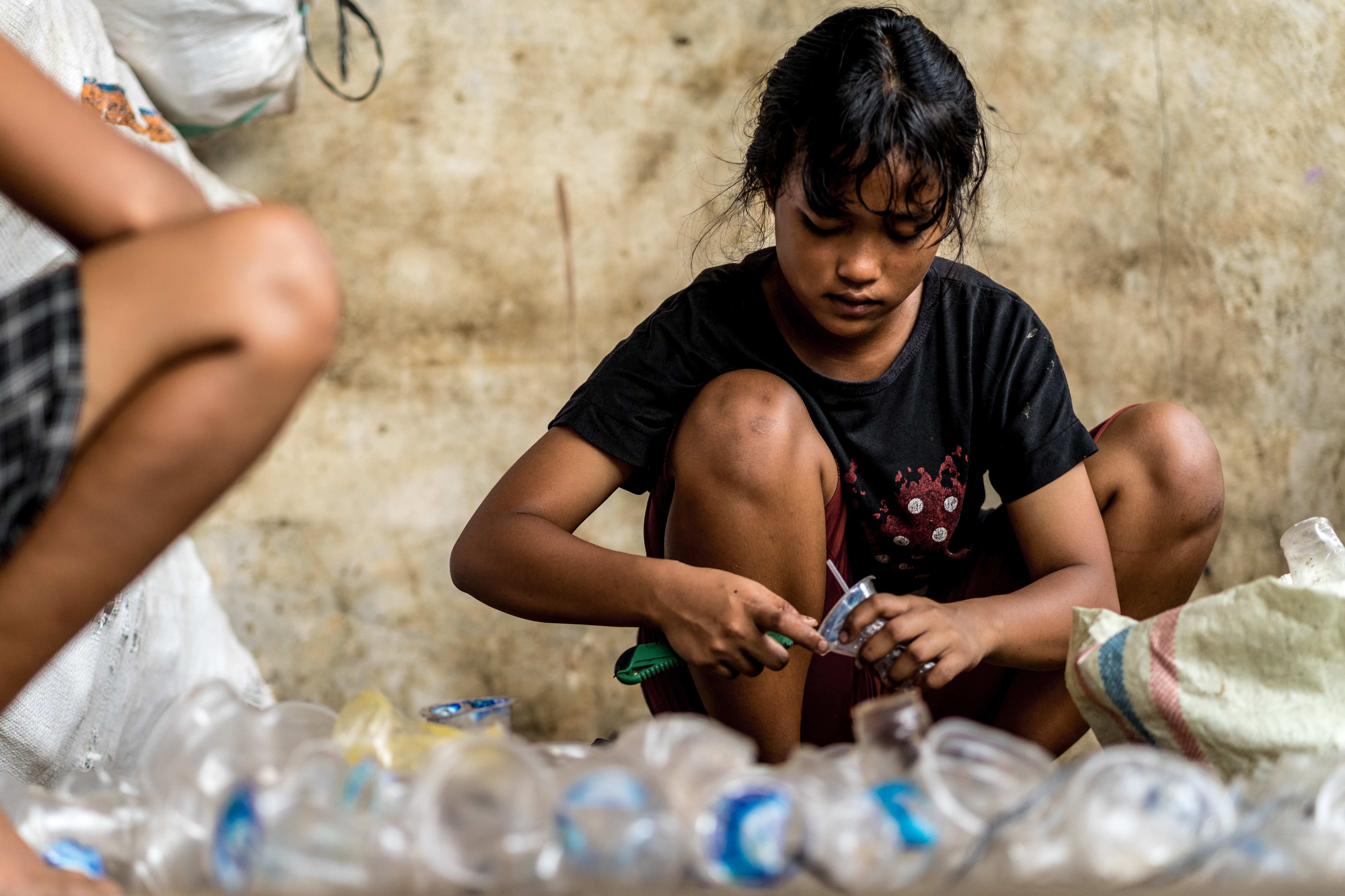 Ein Mädchen aus Indonesien wäscht Plastikflaschen