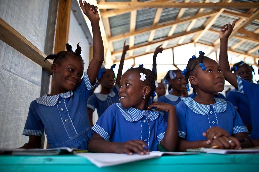 Drei Schulmädchen in Haiti sitzen in der Schule. (Quelle: Jakob Studnar)