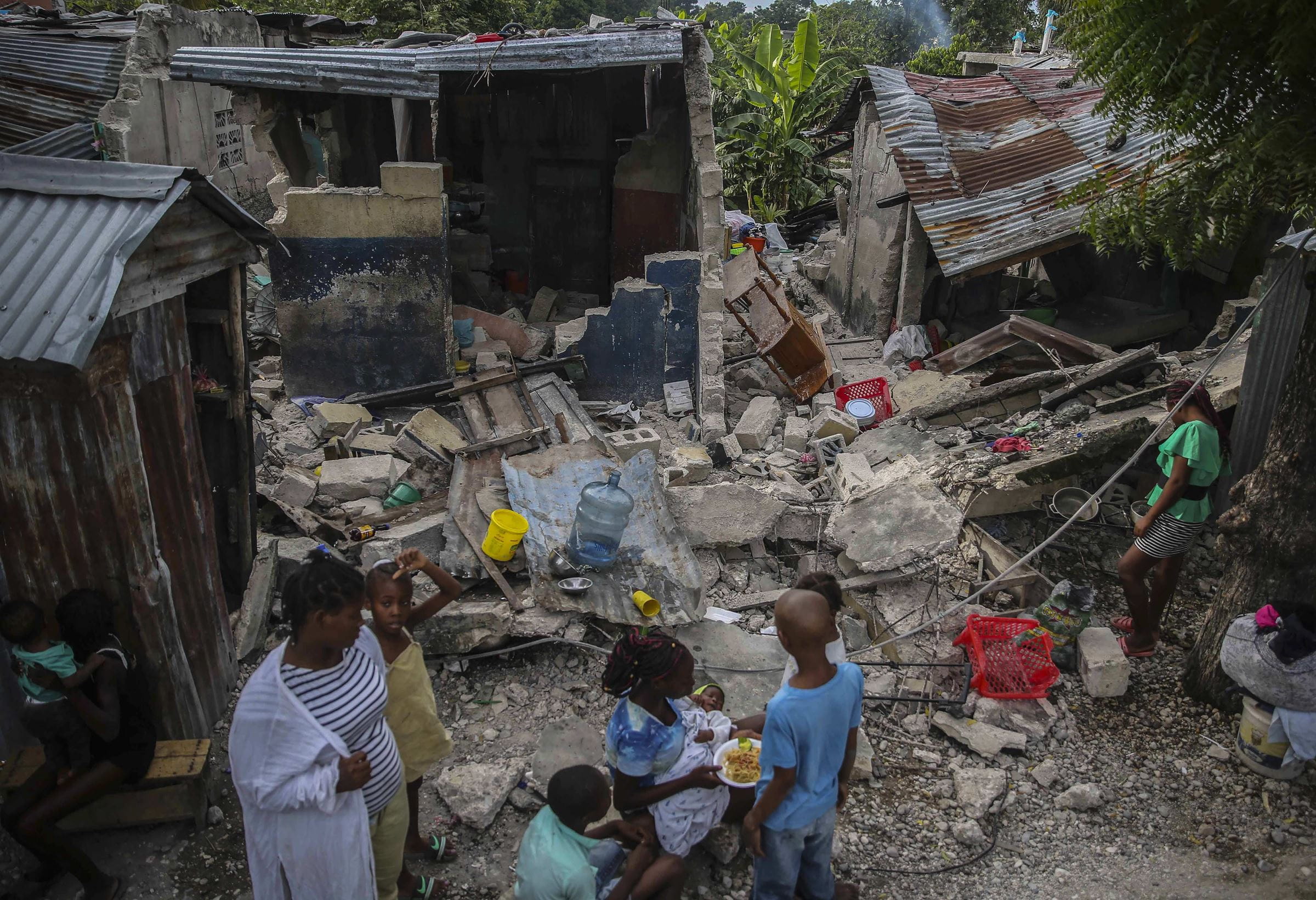 Eine Familie in den Trümmern ihres Hauses, das am 14. August 2021 zerstört wurde (Quelle: picture alliance)