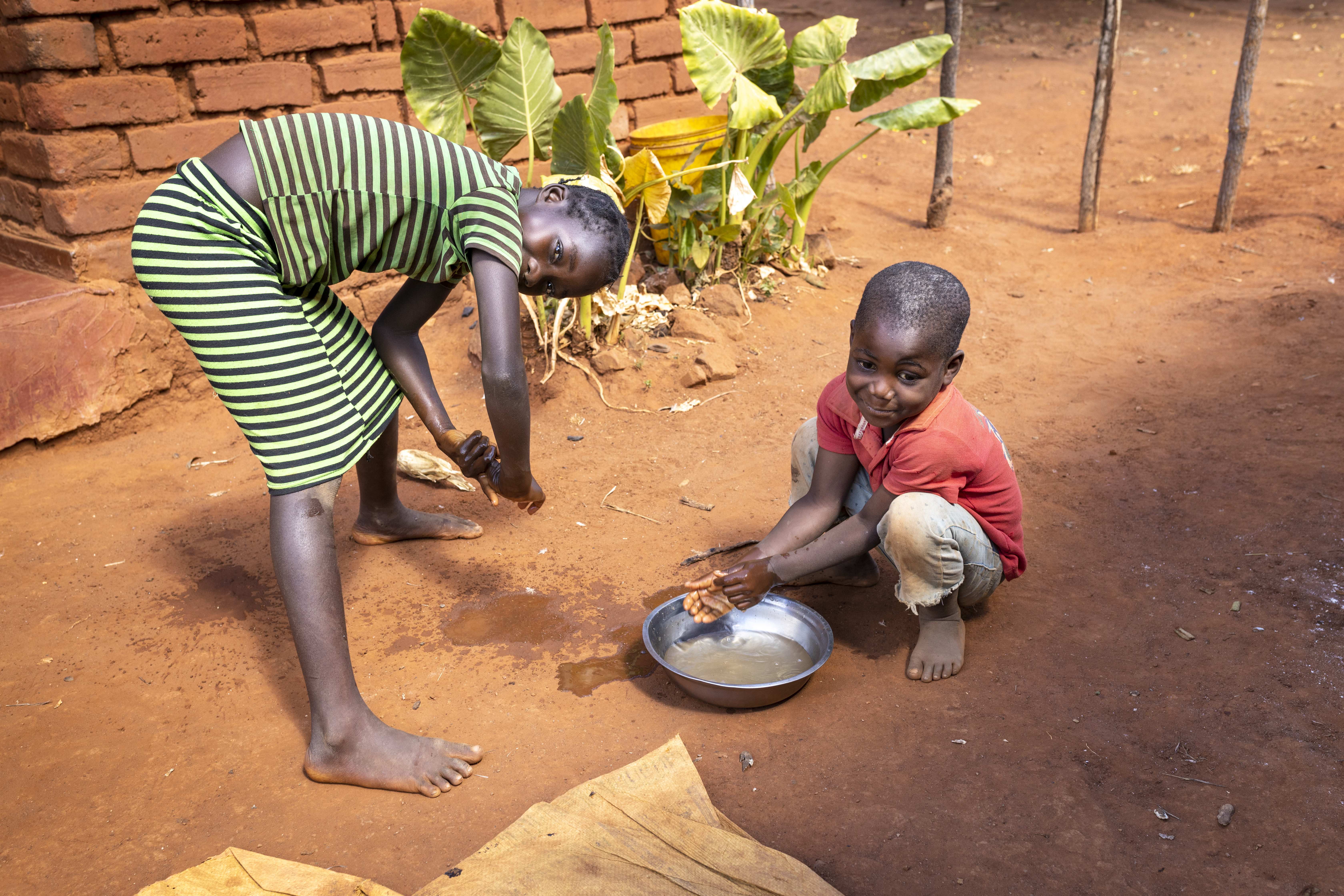 Zwei Kinder beugen sich üner eine Schüssel mit Wasser. (Quelle: Christian O. Bruch)