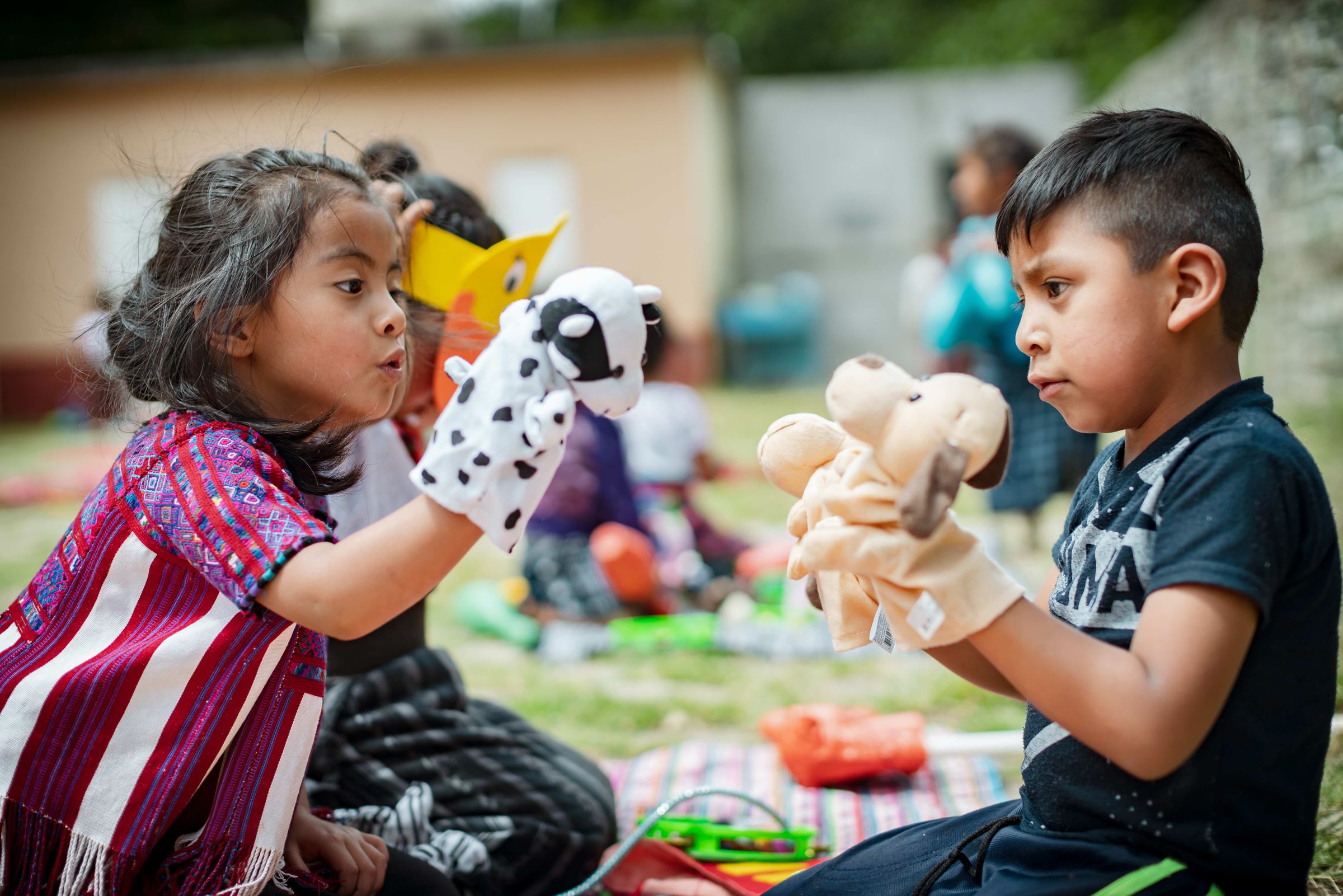 Ein Mädchen und ein Junge aus Guatemala spielen mit Handpuppen. (Quelle: Jakob Studnar)