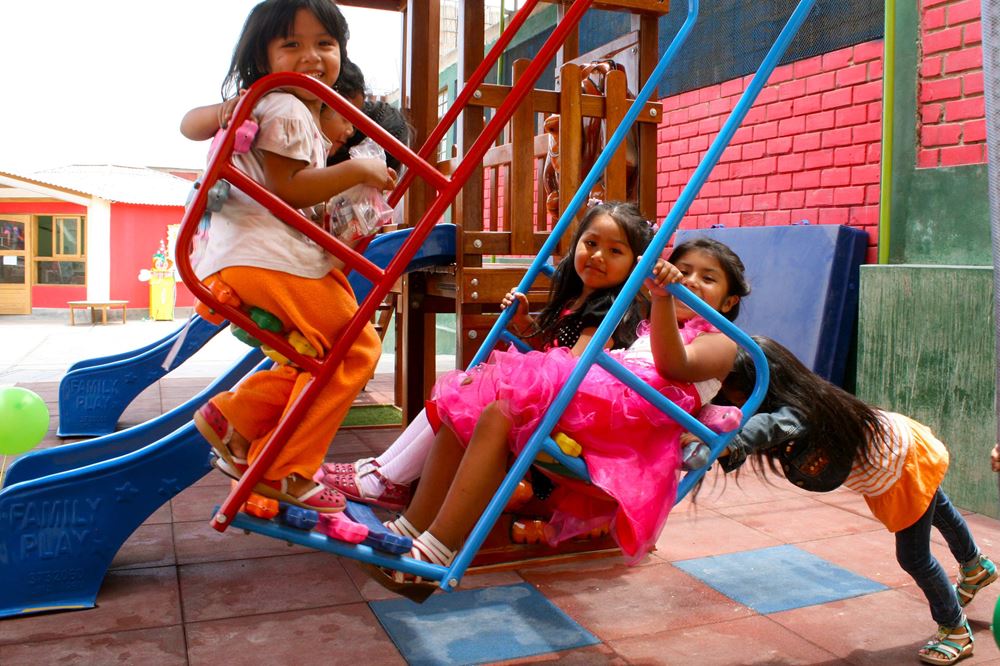 Kinder spielen auf einem Spielplatz in Peru und schaukeln Quelle Juergen Schuebelin