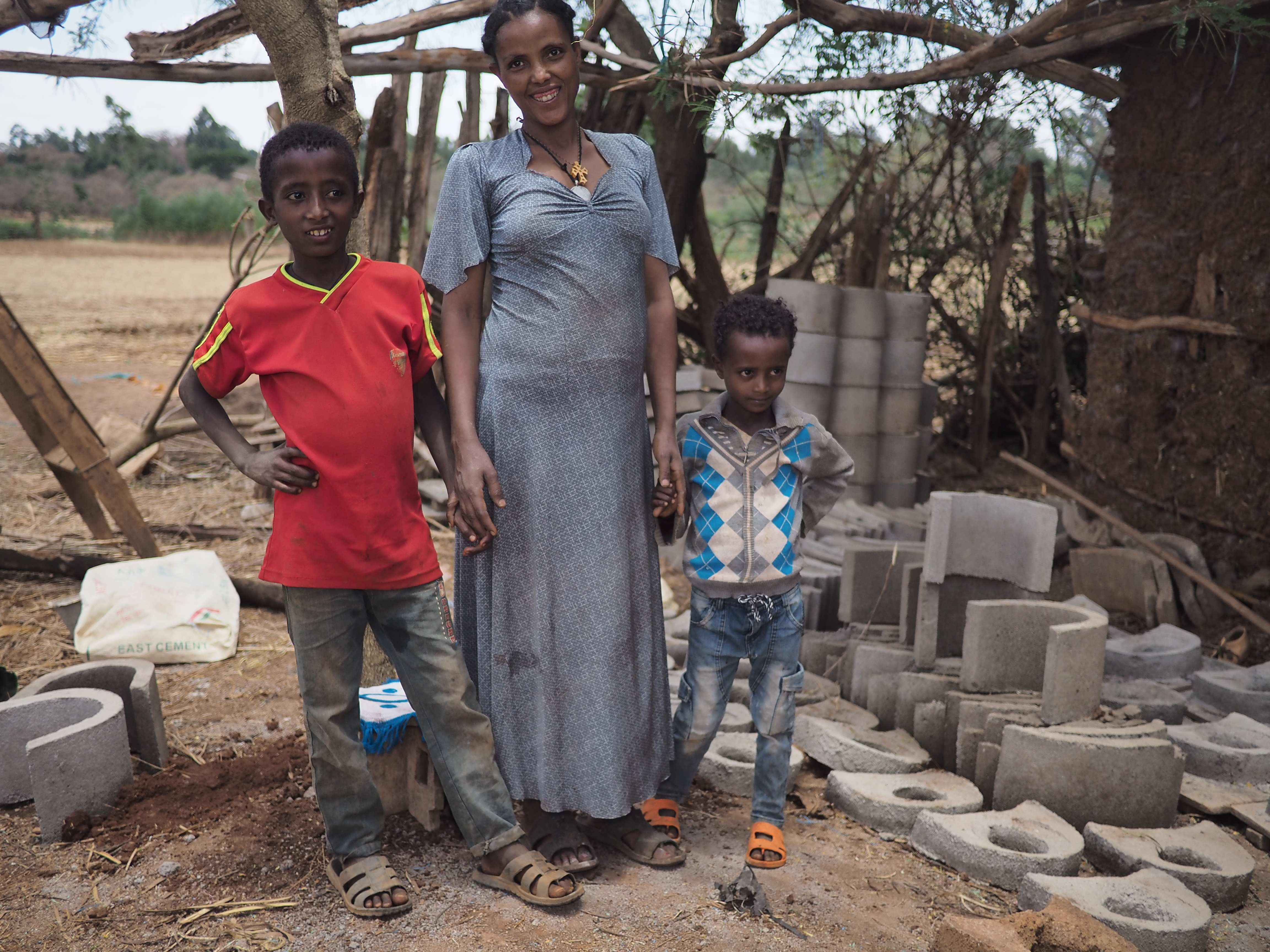 Eine Mutter und ihre zwei Kinder in Äthiopien stehen vor einer Hütte. (Quelle: Malte Pfau)