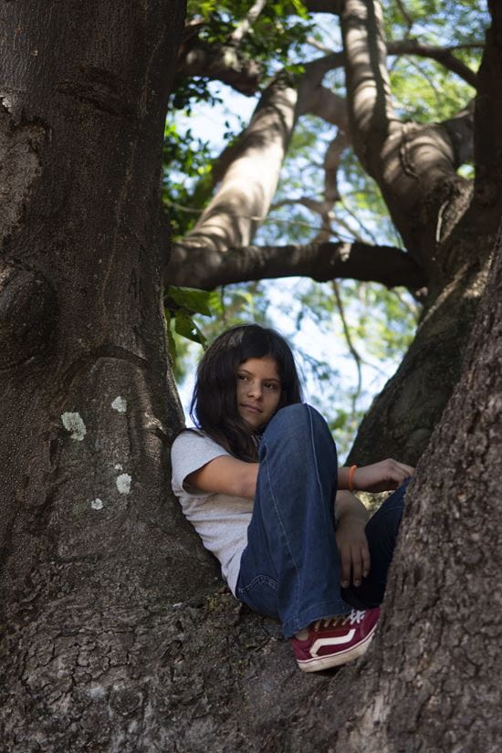 Ein Mädchen aus Honduras sitzt in einem Baum. (Quelle: Christian Nusch)