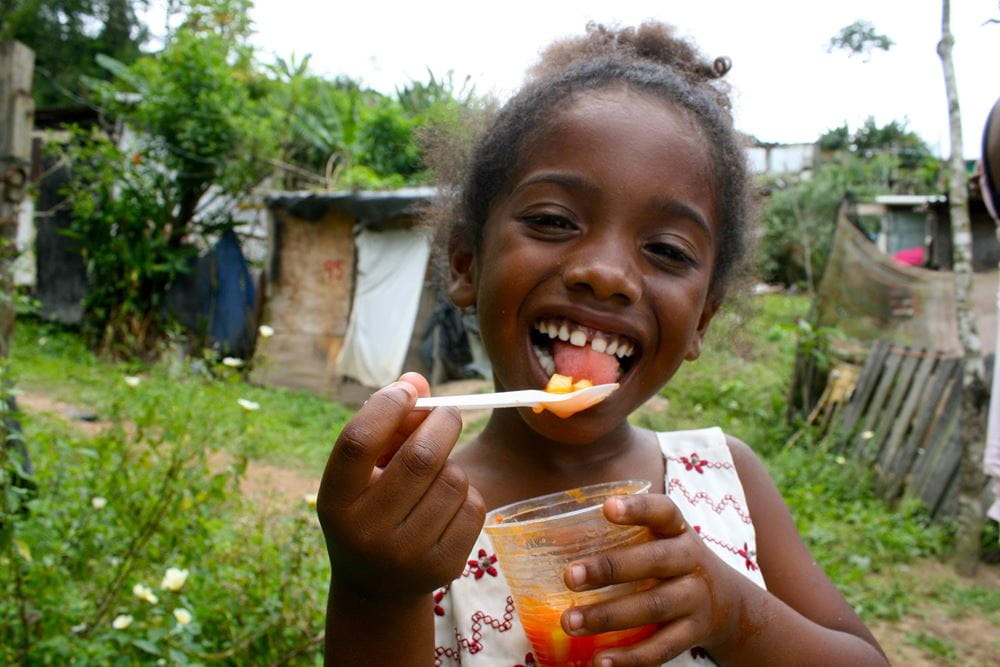 Mädchen isst ihren Fruchtbecher in der Favela (Quelle: Jürgen Schübelin)