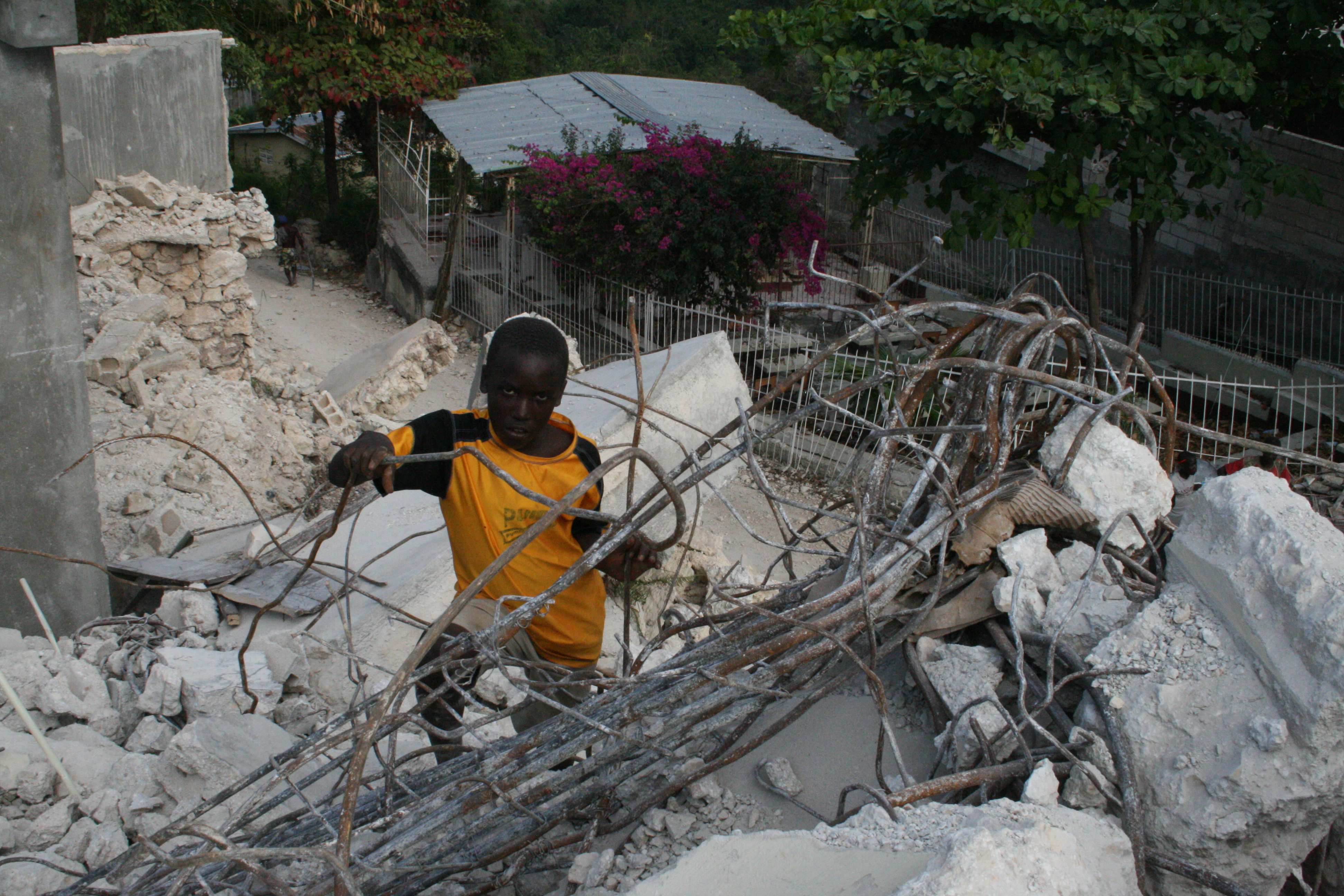 Ein Junge steht auf den zerstörten Gebäuden nach der Naturkatastrophe 2010 Foto: Jürgen Schübelin