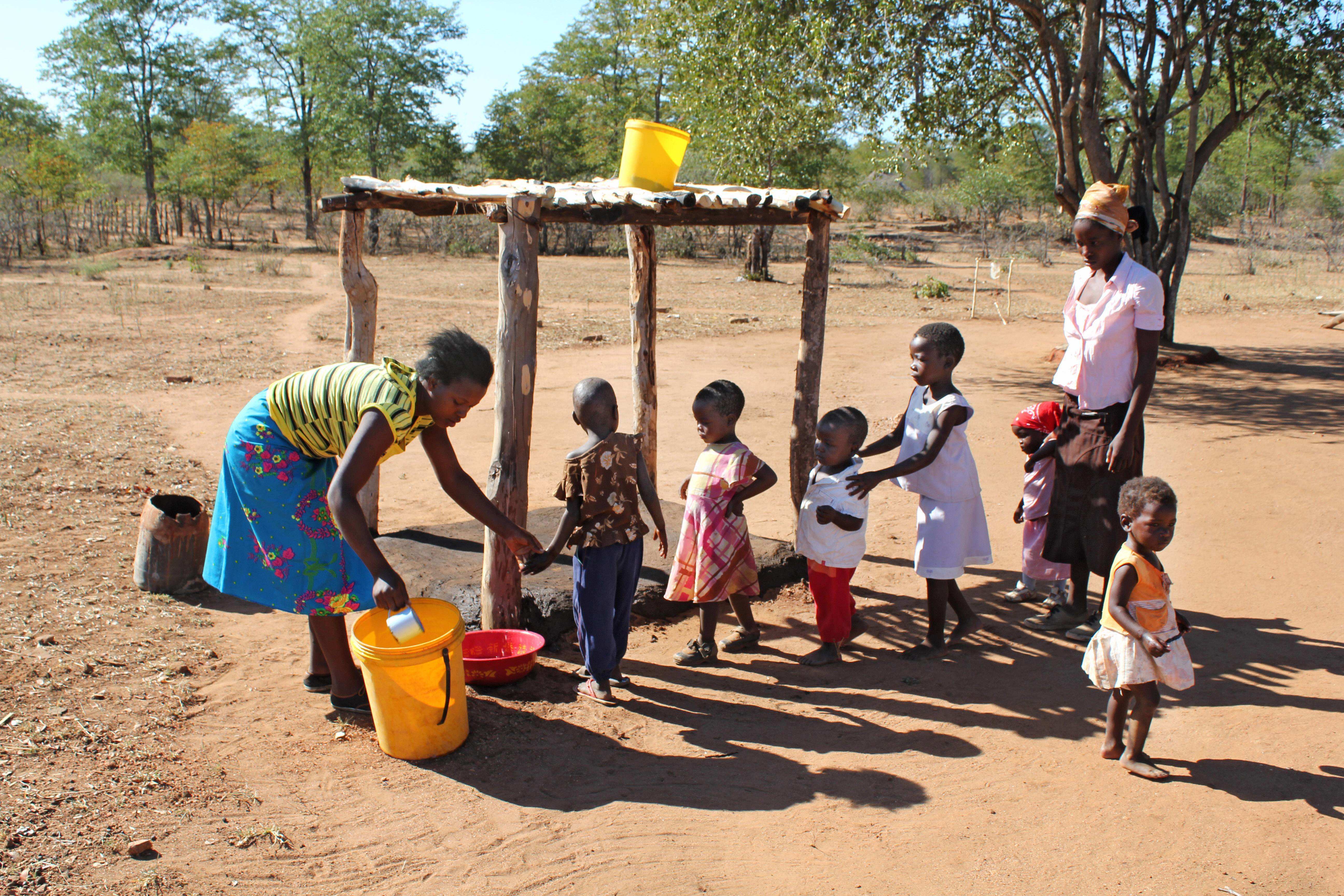 Kinder einer Familie in Simbabwe bekommen Wasser, Foto: imago0059718204h