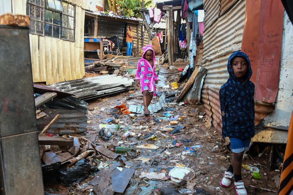Kinder stehen nach den Überschwemmungen in Südafrika vor den Trümmern ihrer Häuser (Quelle: Imago/Darren Stewart)