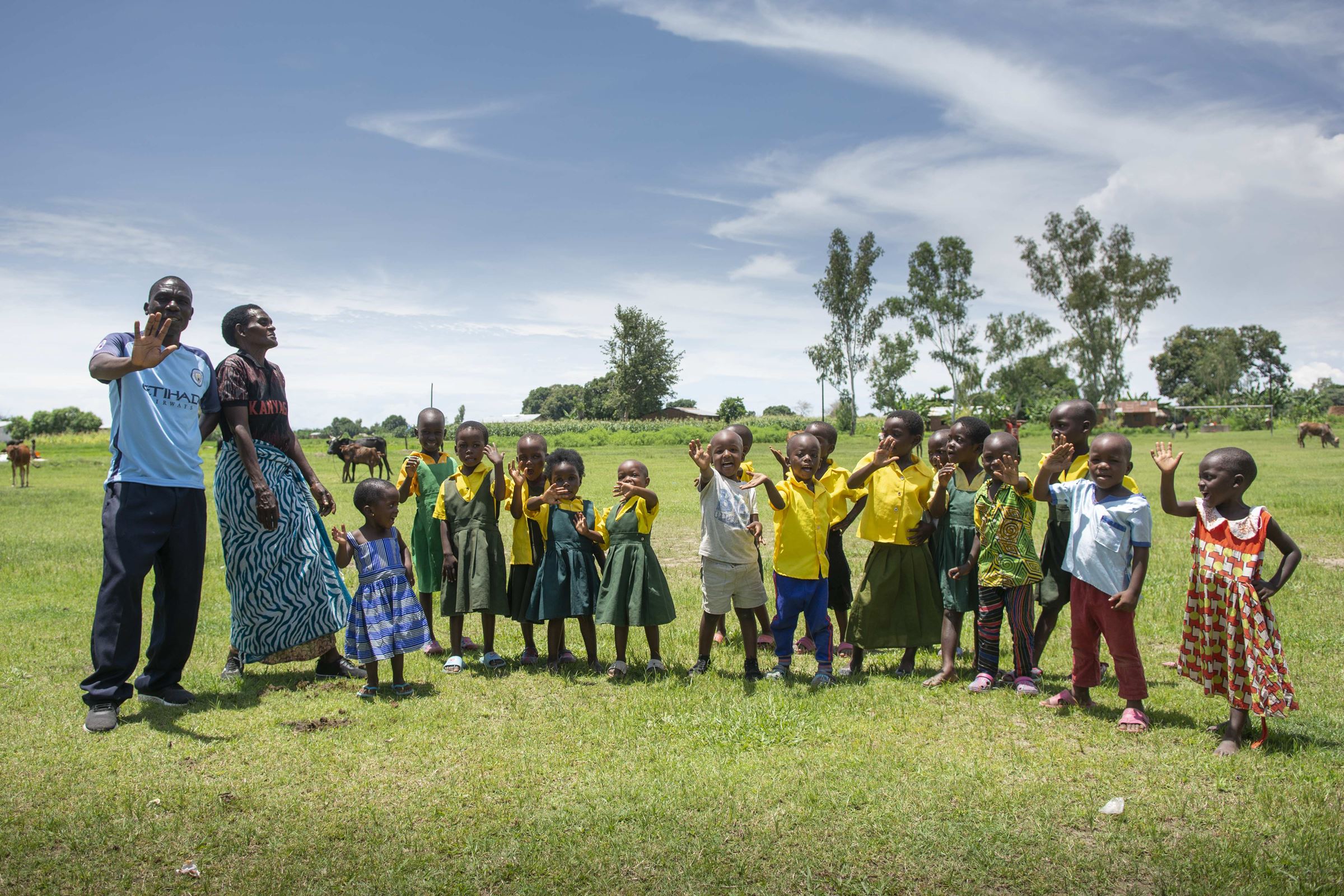 Malawi: Eine Kindergruppe aus der Vorschule lacht und winkt. (Quelle: Christian Nusch)