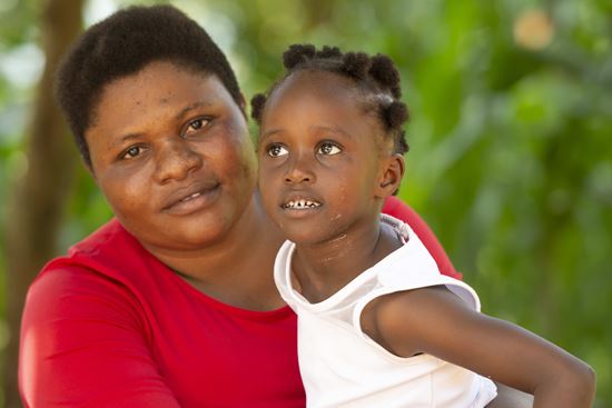 Portraitfoto von Hawa, die ihre kleine Tochter auf dem Arm hält. Beide lachen. (Quelle: Christian Nusch) Portraitfoto von Hawa, die ihre kleine Tochter auf dem Arm hält. Beide lachen. (Quelle: Christian Nusch)