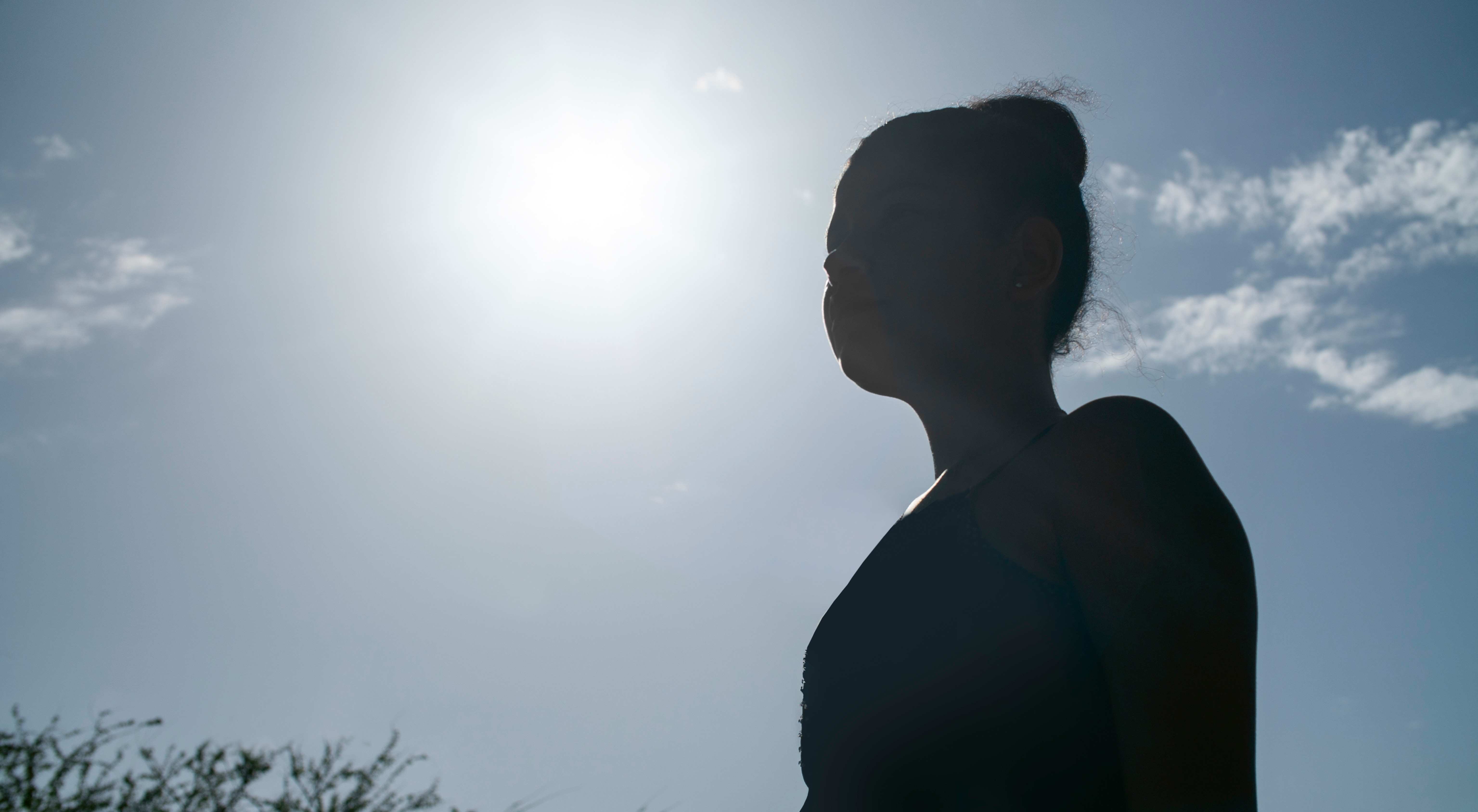Gegenlichtaufnahme eines Mädchens, das nur schemenhaft zu erkennen ist, vor blauem Himmel (Quelle: Projektpartner)