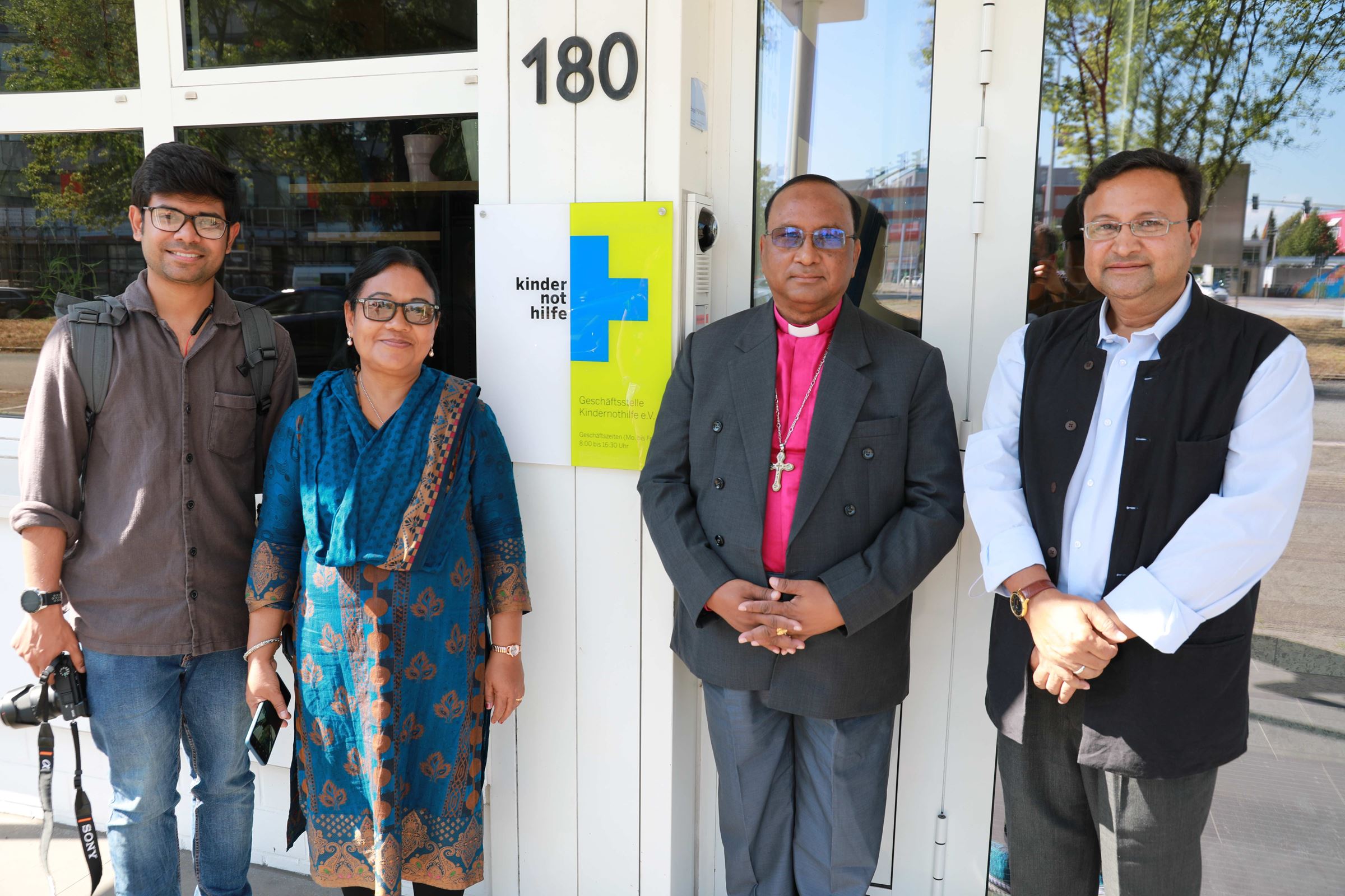 Peter Mandal (sein Vater war Patenkind), Monita Mankhin, Bischof Samuel Sunil Mankhin (beide waren Patenkinder), Reverend John Probhudan Hira vor der Geschäftsstelle (Quelle: Ralf Krämer) Peter Mandal (sein Vater war Patenkind), Monita Mankhin, Bischof Samuel Sunil Mankhin (beide waren Patenkinder), Reverend John Probhudan Hira vor der Geschäftsstelle (Quelle: Ralf Krämer)