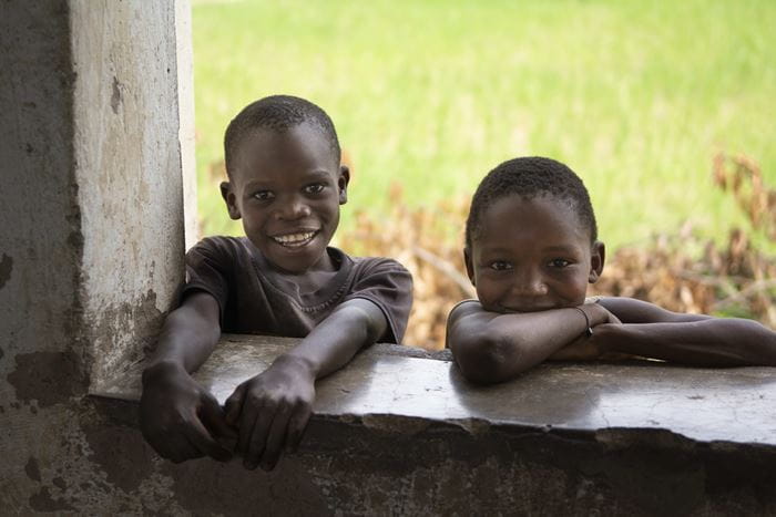 Kinder in Malawi schauen durch ein Fenster (Quelle: Christian Nusch)