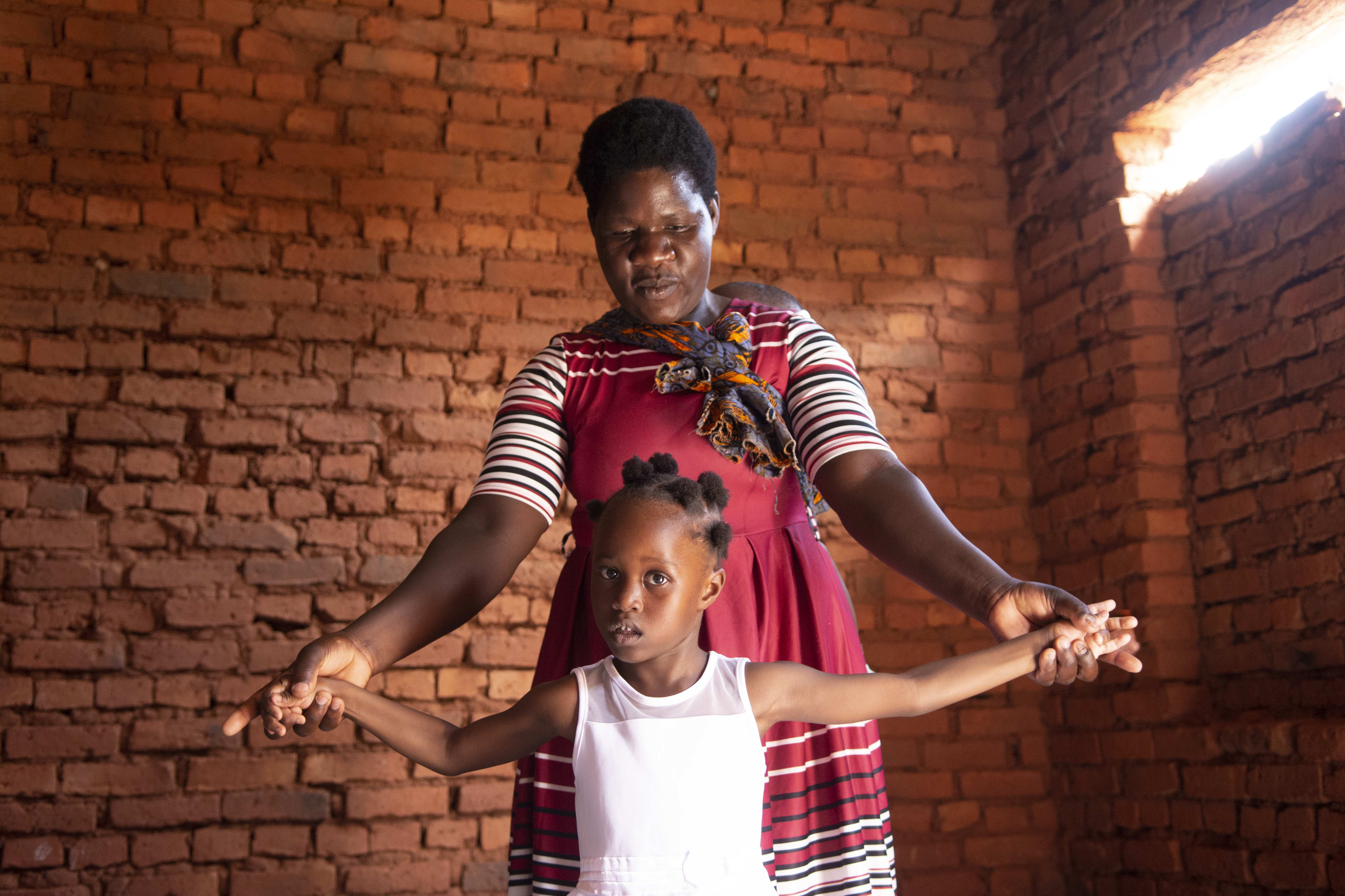 Ein Mädchen aus Malawi übt das Laufen mit seiner Mutter. (Quelle: Christian Nusch)