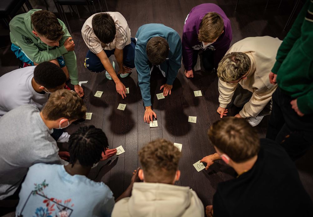 Eine Gruppe von Jugendlichen arbeitet im Workshop zusammen. Sie schauen auf den Foto und sortieren kleine Zettel zum Thema Schutz vor Gewalt. Foto Jakob Studnar Platzhalterbild