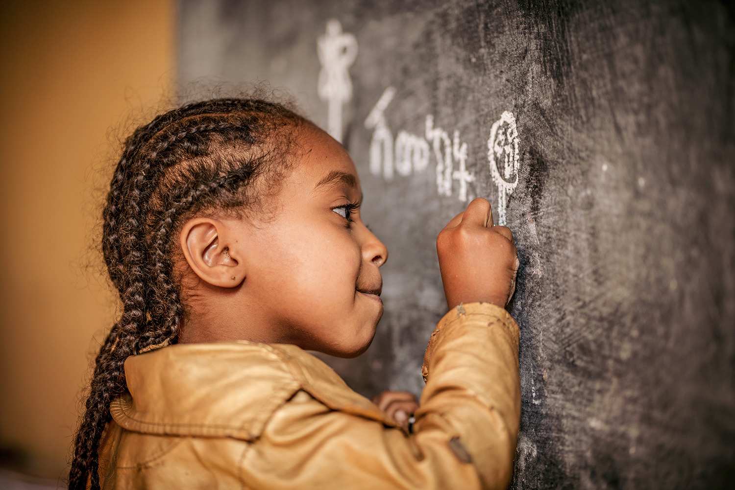 Kind malt mit Kreide an eine Tafel (Selbsthilfegruppen Äthiopien) (Quelle: Jakob Studnar)