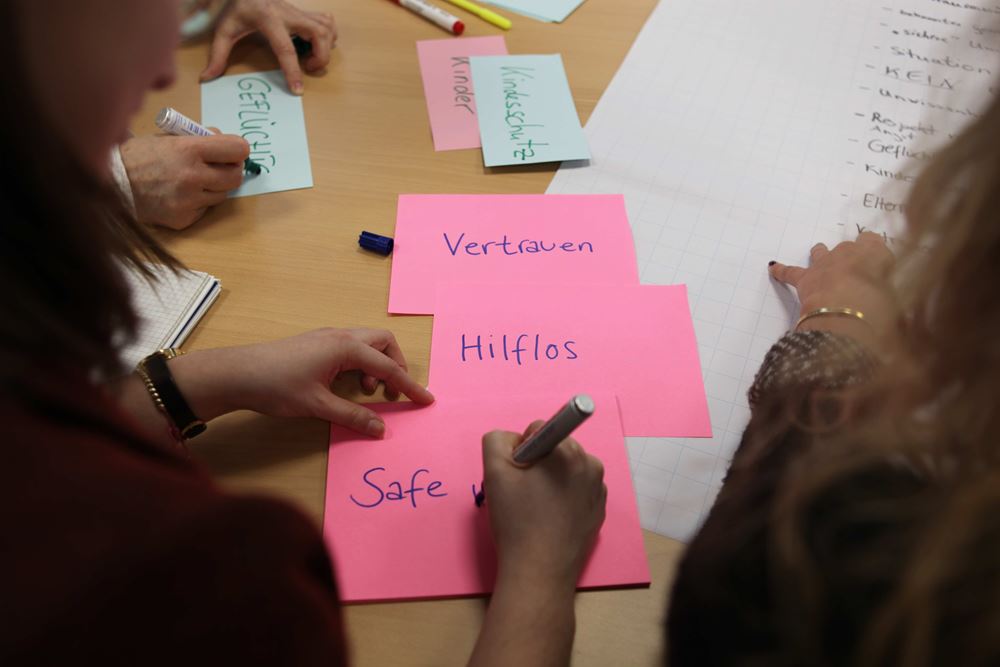 Bei einer Schulung schreiben Teilnehmende zentrale Begriffe auf Papier. Foto: Kindernothilfe