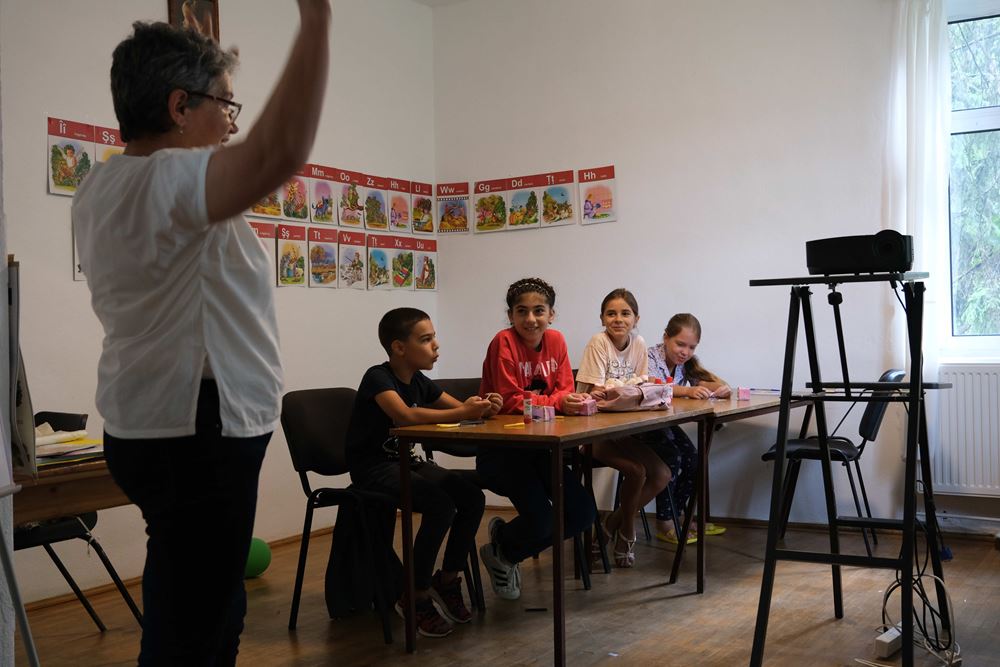Kinder sitzen an einem Tisch vor einem Projektor. (Quelle: Angelika Böhling) Kinder sitzen an einem Tisch vor einem Projektor. (Quelle: Angelika Böhling)