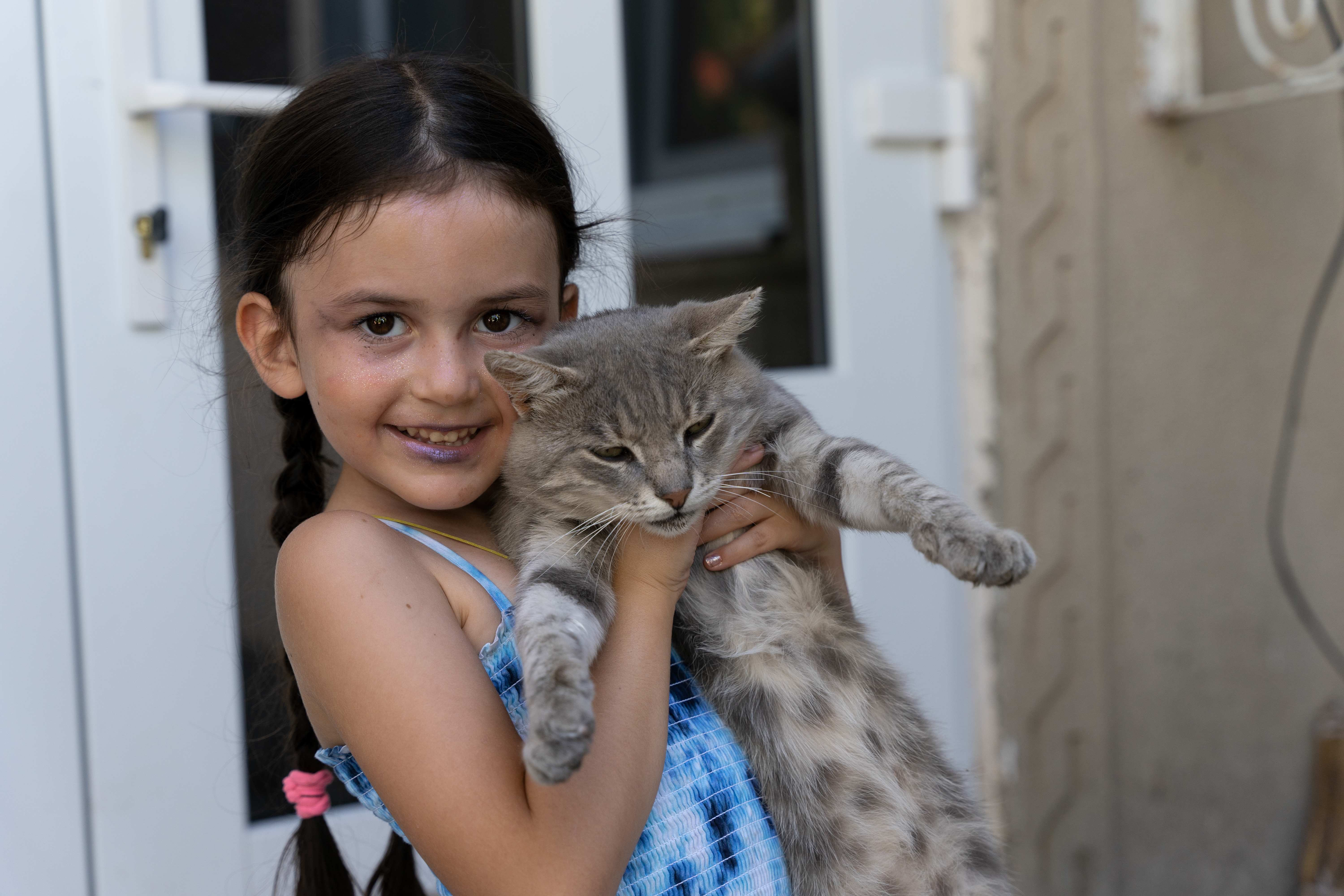 Ein Mädchen hält eine Katze im Arm. (Quelle: Christian Nusch)