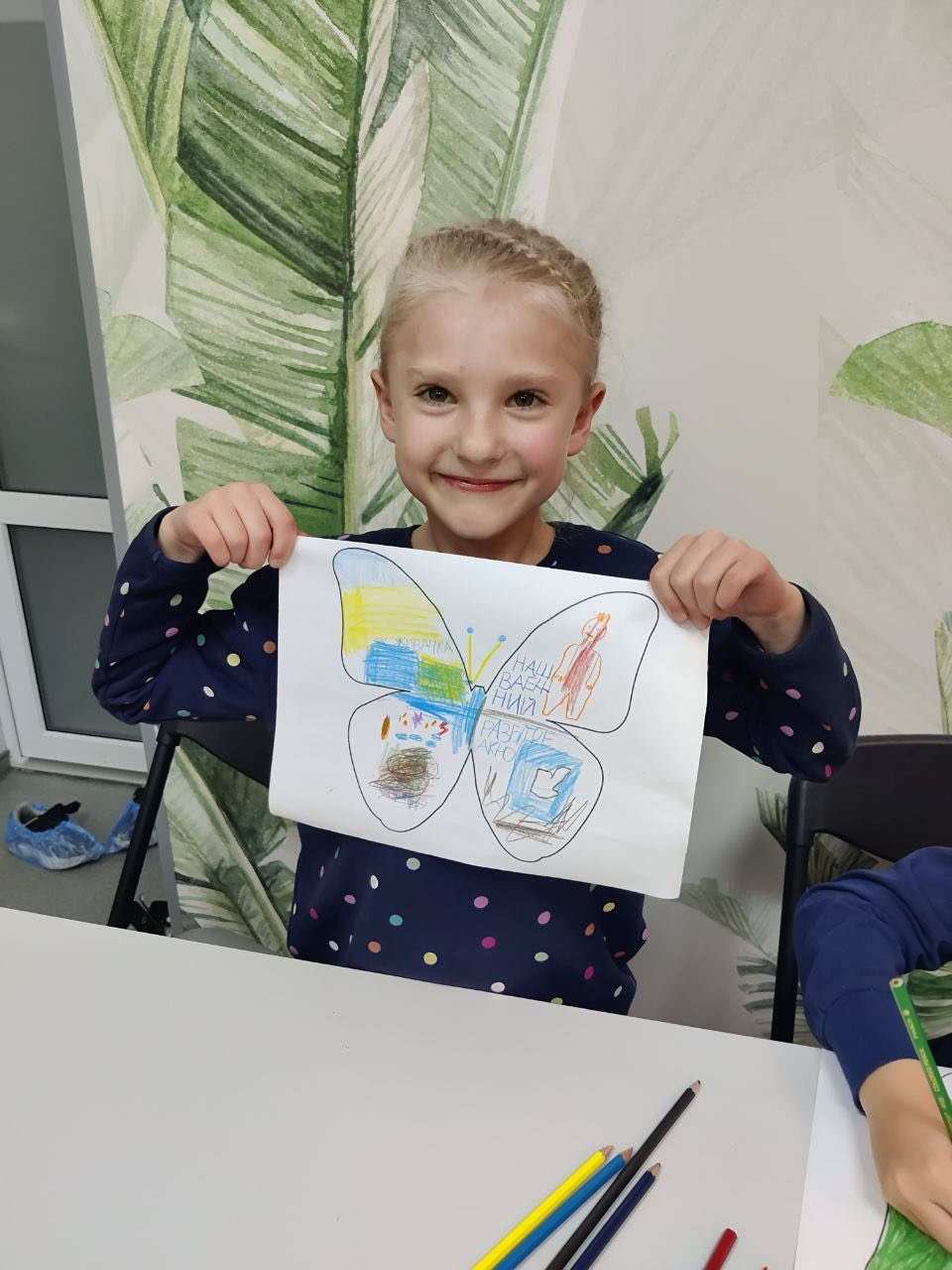Ein Mädchen aus Charkiw hält ein selbst gemaltes Bild hoch.  (Quelle: Myrne Nebo)