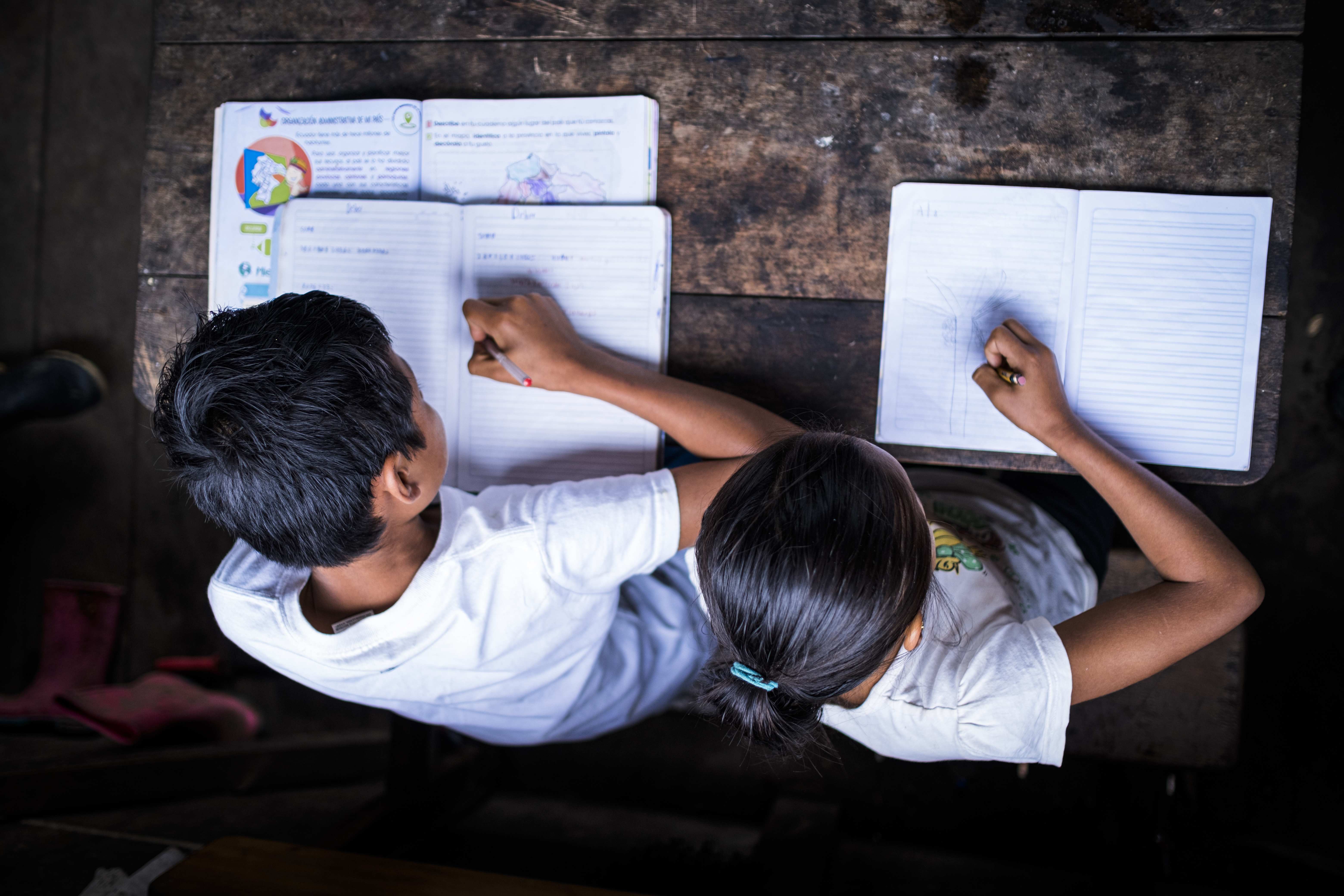 Zwei Kinder aus Ecuador schreiben. (Quelle: Martin Bondzio)