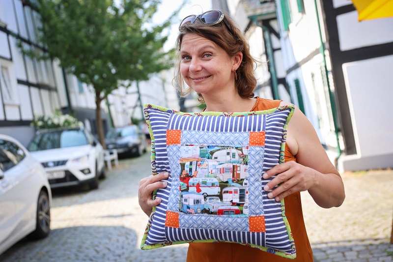 Eine Frau hat ein Patchwork-Kissen beim Arbeitskreis Siegerland gekauft (Quelle: Ludwig Grunewald)