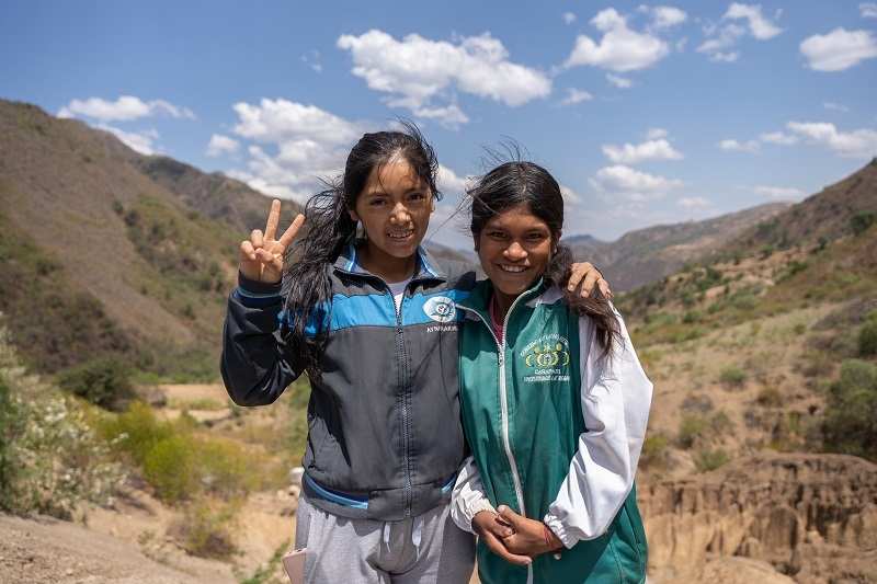 Wayras Schwester Amancaya mit Soledad Saigua Puma, der Koordinatorin des Kindernothilfepartners Ayninakuna, vor einer Berglandschaft (Quelle: Christian Nusch)