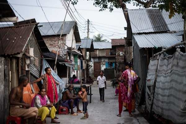 Bangladesch: Slum, Menschen sitzen und stehen vor ihren Hütten (Quelle: Lars Heidrich)