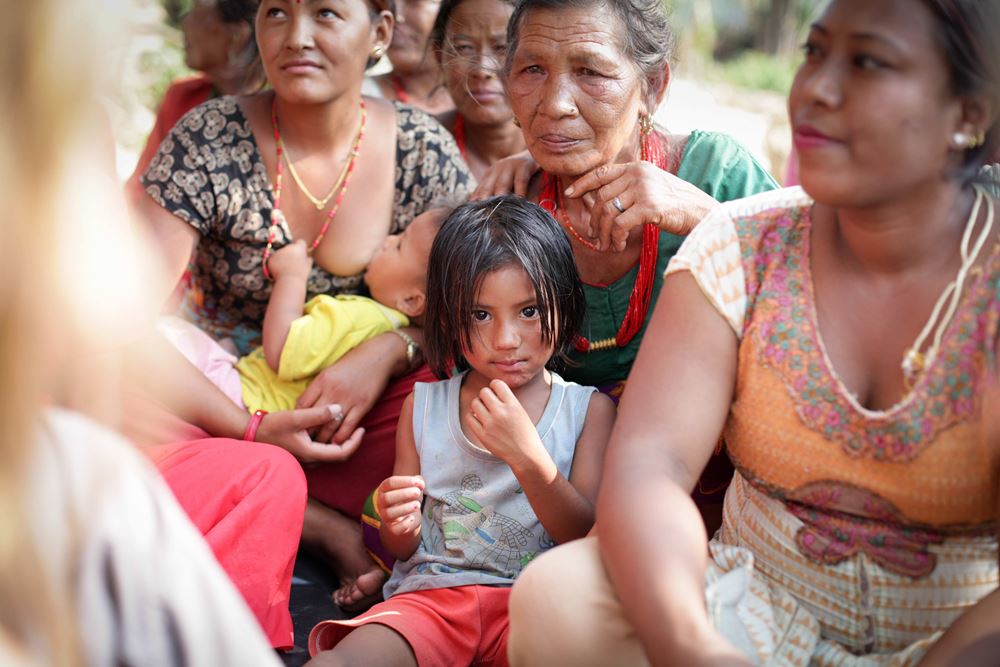 Nepal: Erdbeben 2015 Pressereise - Kind umgeben von Frauen Nepal: Erdbeben 2015 Pressereise - Kind umgeben von Frauen