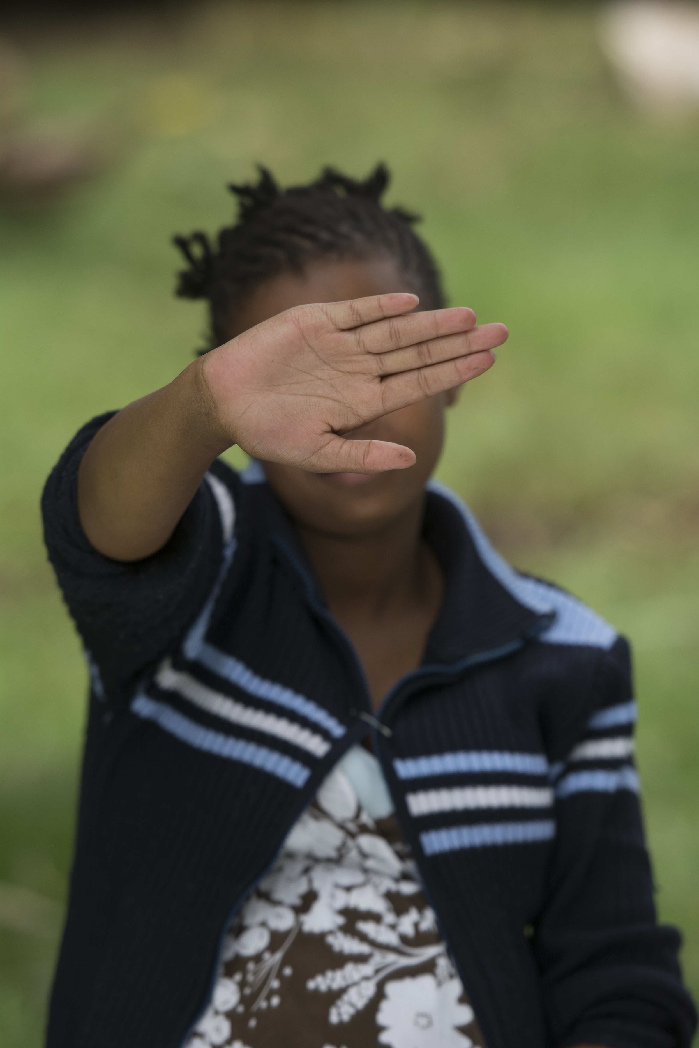Ein Mädchen aus Kenia versteckt ihr Gesicht hinter ihrer Hand. (Quelle: Christian Nusch)