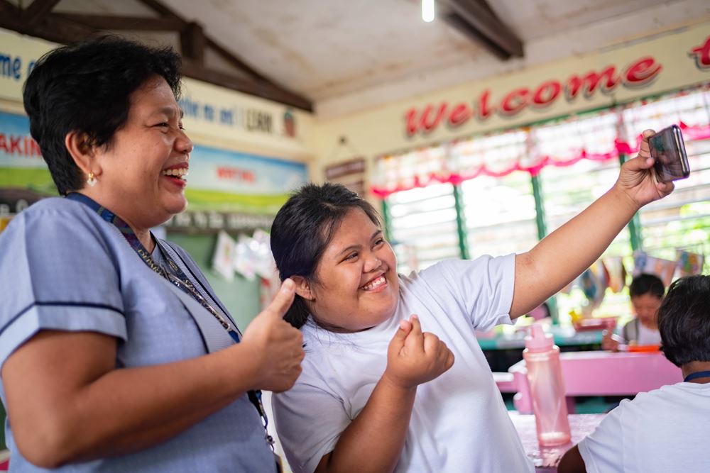 Ein lachendes Mädchen macht ein Selfie von sich und seiner Lehrerin (Quelle: Jakob Studnar)