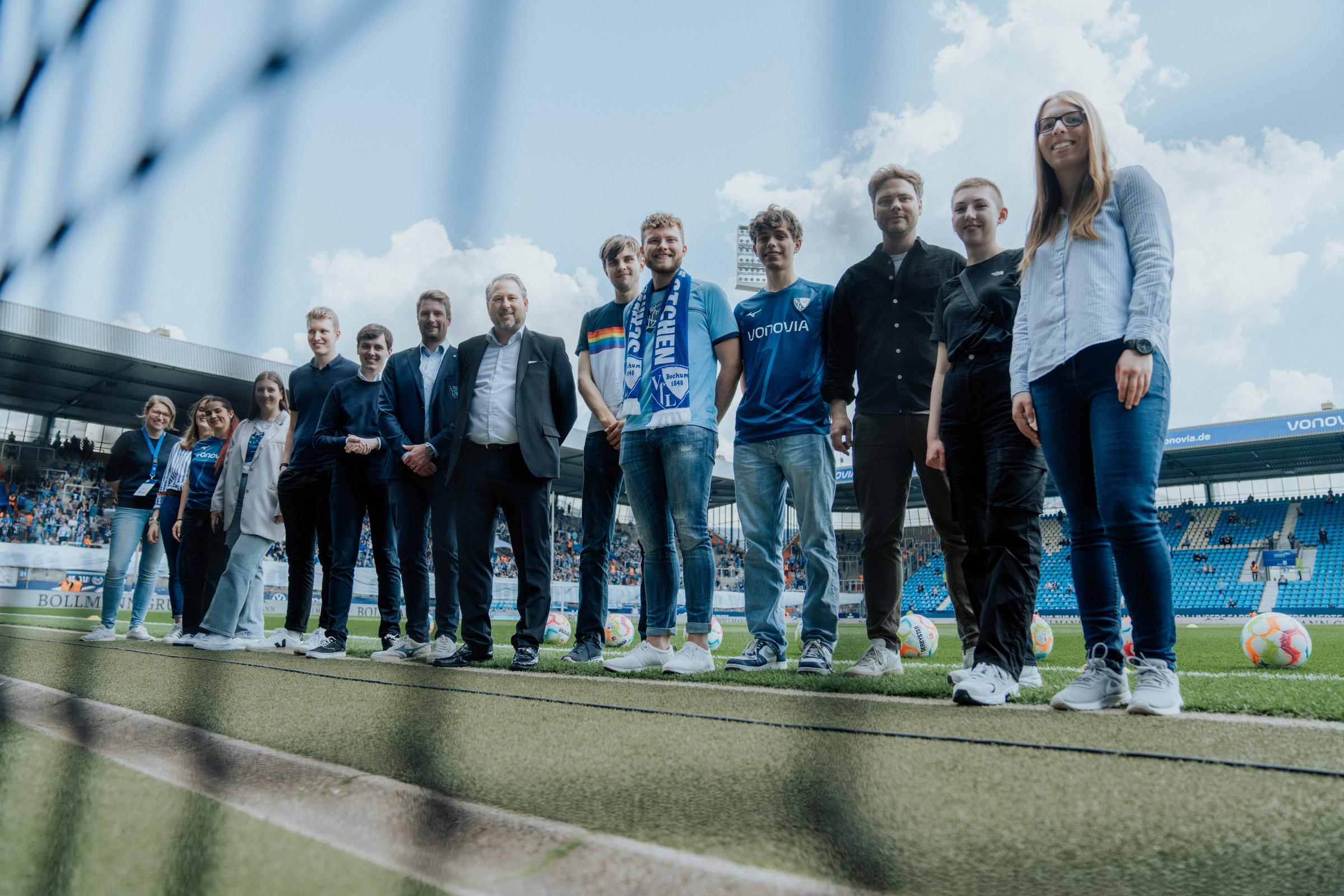 Junge Leute stehen in einem Fußballstadion vor einem Tornetz (Quelle: VfL Bochum 1848 Junge Leute stehen in einem Fußballstadion vor einem Tornetz (Quelle: VfL Bochum 1848