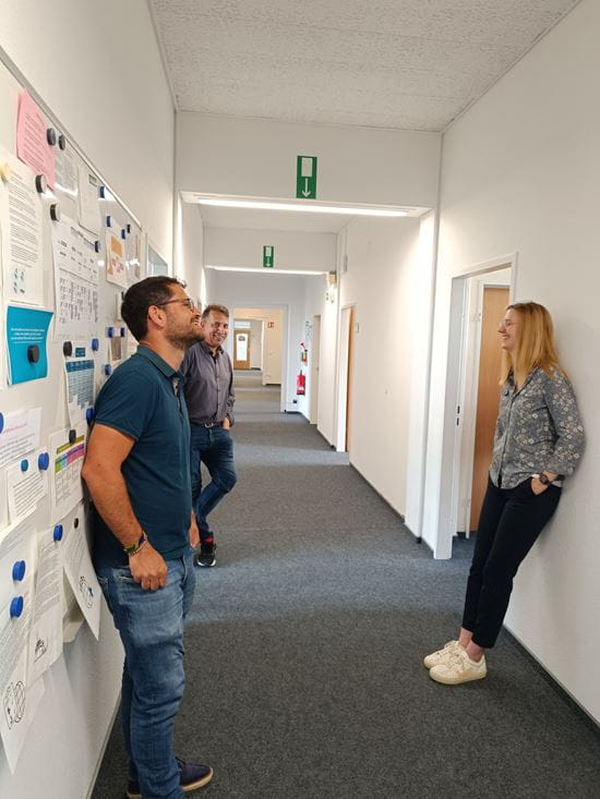 Colleagues talking in the office hall (source: Kindernothilfe)