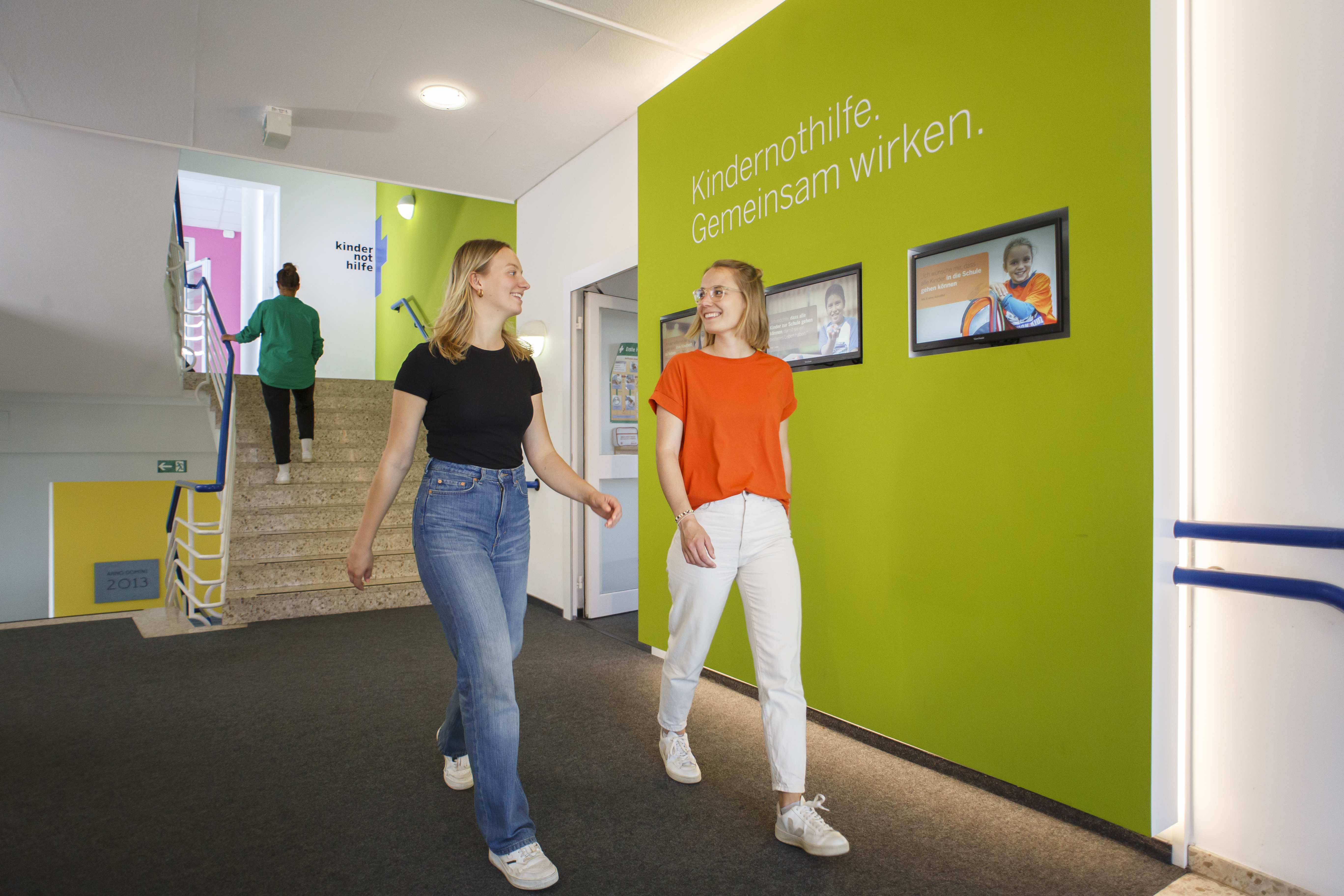 Zwei Kolleginnen laufen durch das Foyer der Kindernothilfe (Quelle: Niklas von Bonn)