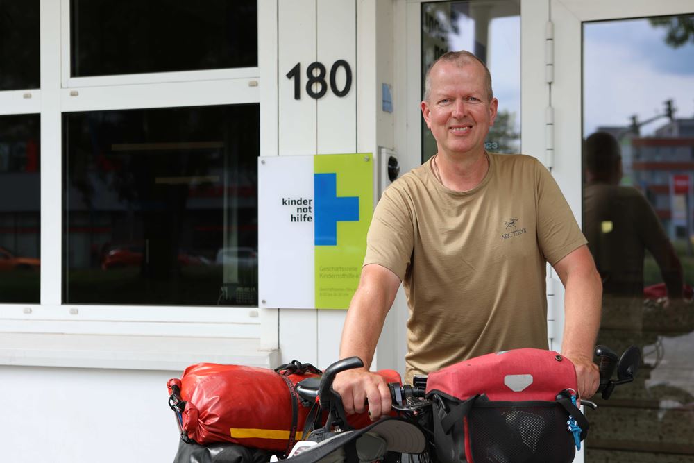 Christian Jung mit Fahrrad vor der Tür zur Geschäftsstelle der Kindernothilfe (Quelle: Katharina Draub) Christian Jung mit Fahrrad vor der Tür zur Geschäftsstelle der Kindernothilfe (Quelle: Katharina Draub)