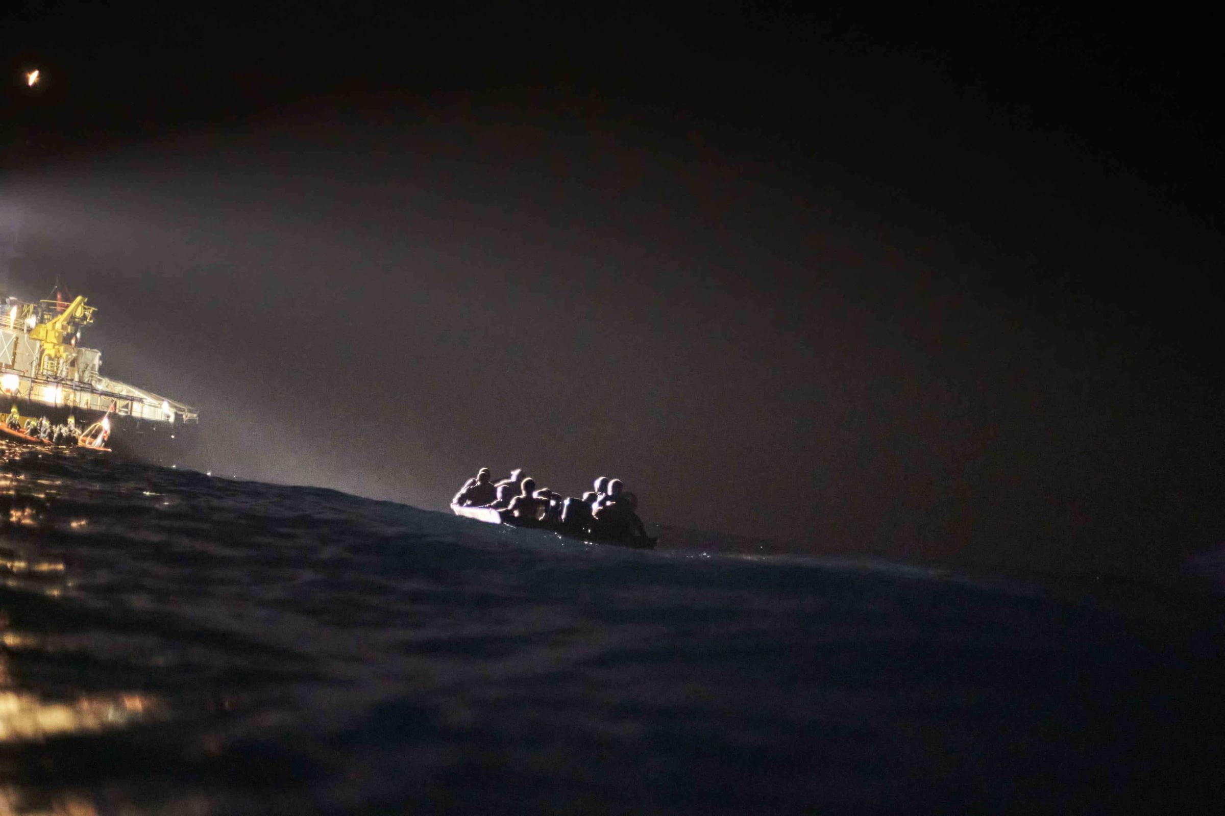 Ein Seenotrettungsschiff strahlt nachts auf dem Meer ein Boot mit Geflüchteten an (Quelle: Raphael Schumacher(SOS Humanity)