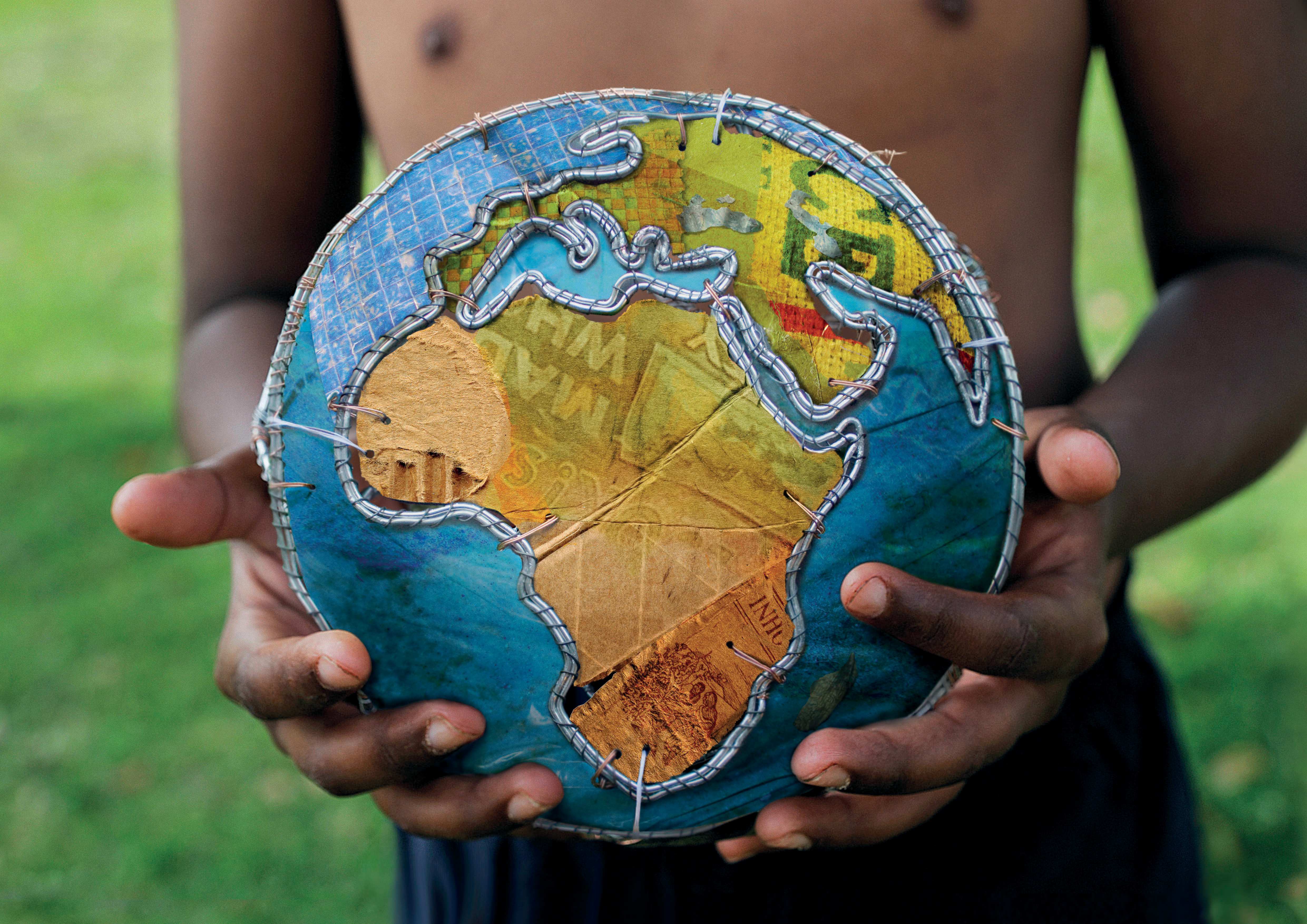 Ein Junge hält einen Ball, der wie ein Globus aussieht