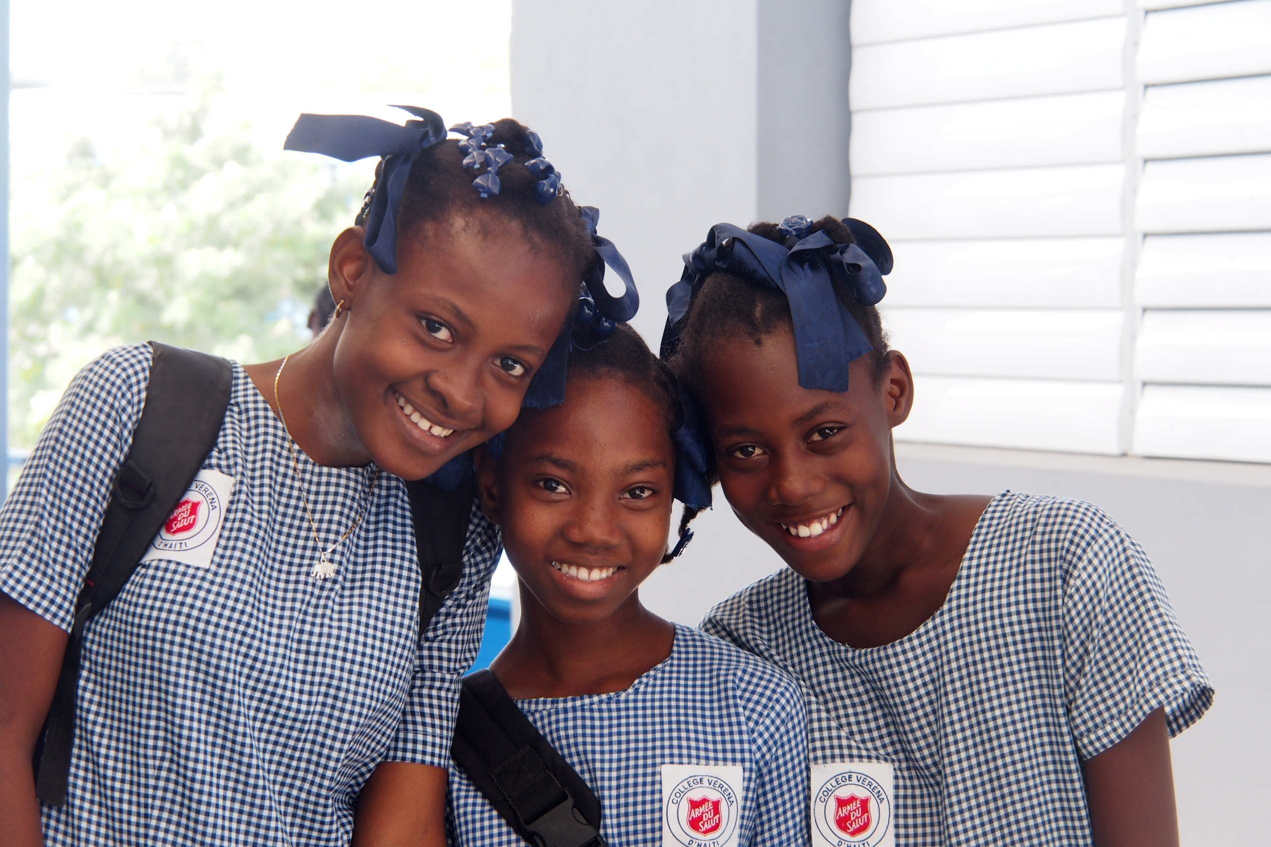 Schulmädchen aus Haiti lächeln in Kamera