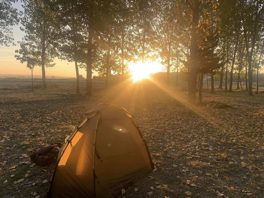 Sonnenuntergang in einem Wald, im Vordergrund ein Zelt (Quelle: Christian Jung) Sonnenuntergang in einem Wald, im Vordergrund ein Zelt (Quelle: Christian Jung)